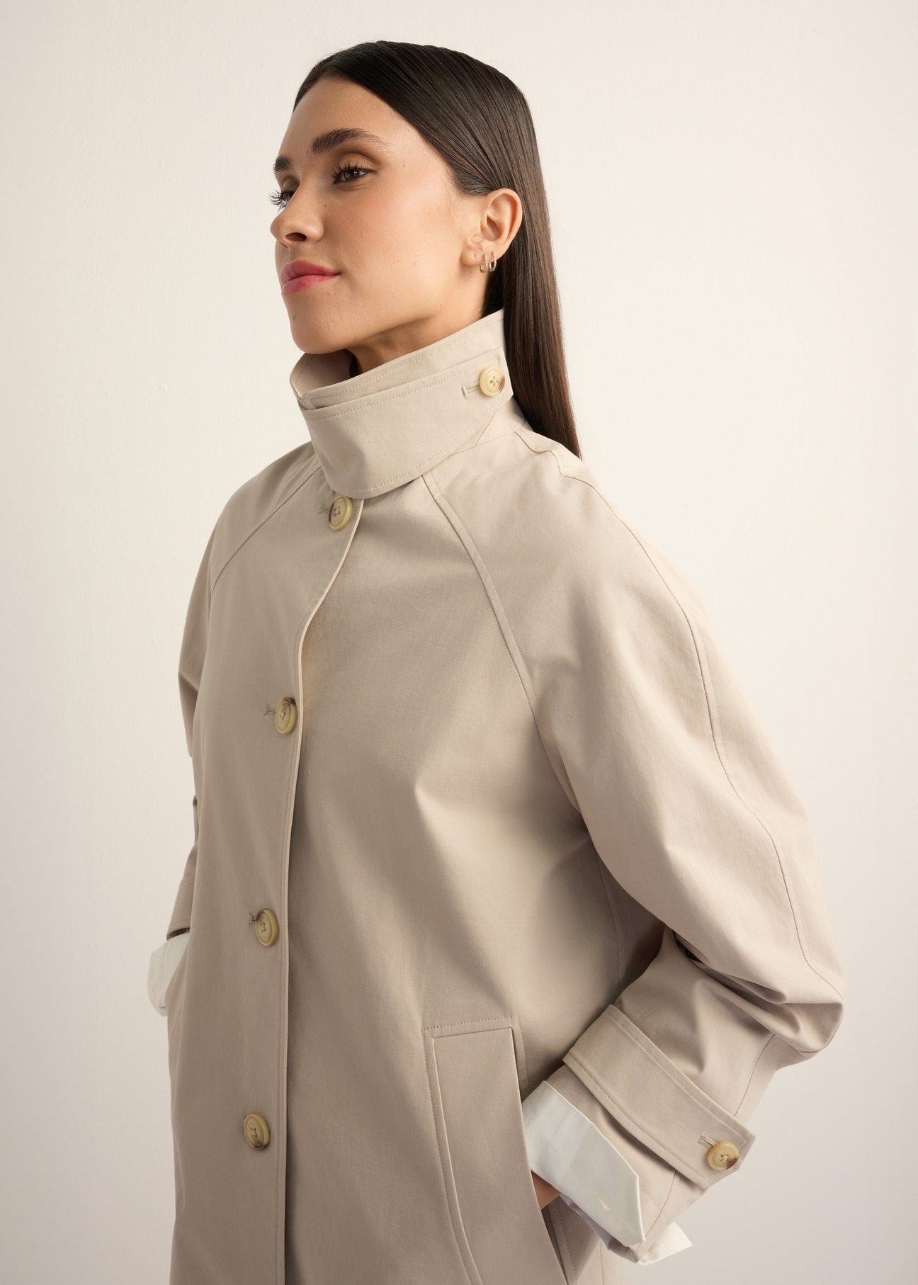 Long beige women's coat KURDT-0692-1J(Z26), diagonal view of the product on the model. Half of the silhouette visible.