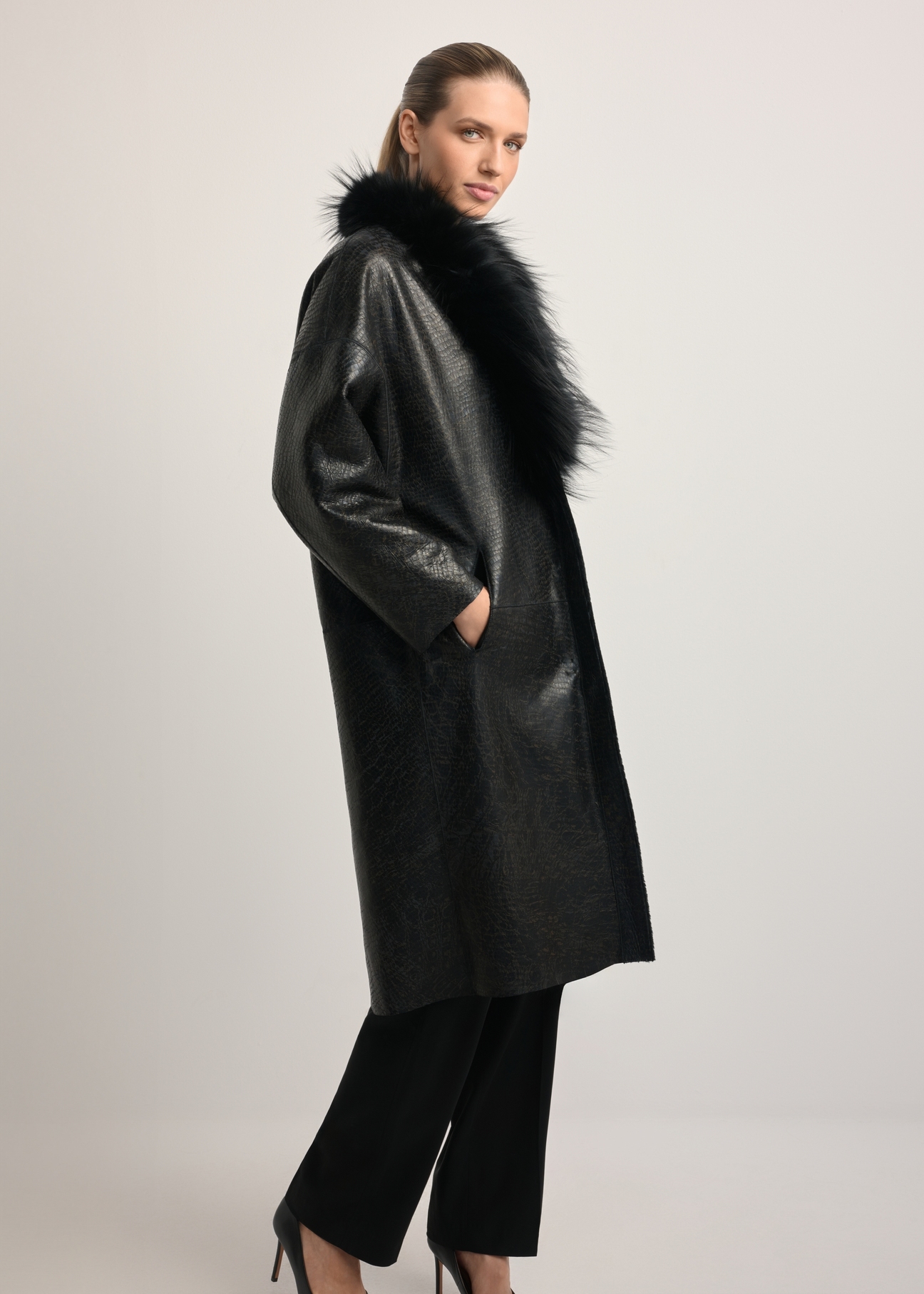 Black leather double-sided women's sheepskin coat KOZDS-0093-1396(Z25), side view of the product on the model. Full body visible.