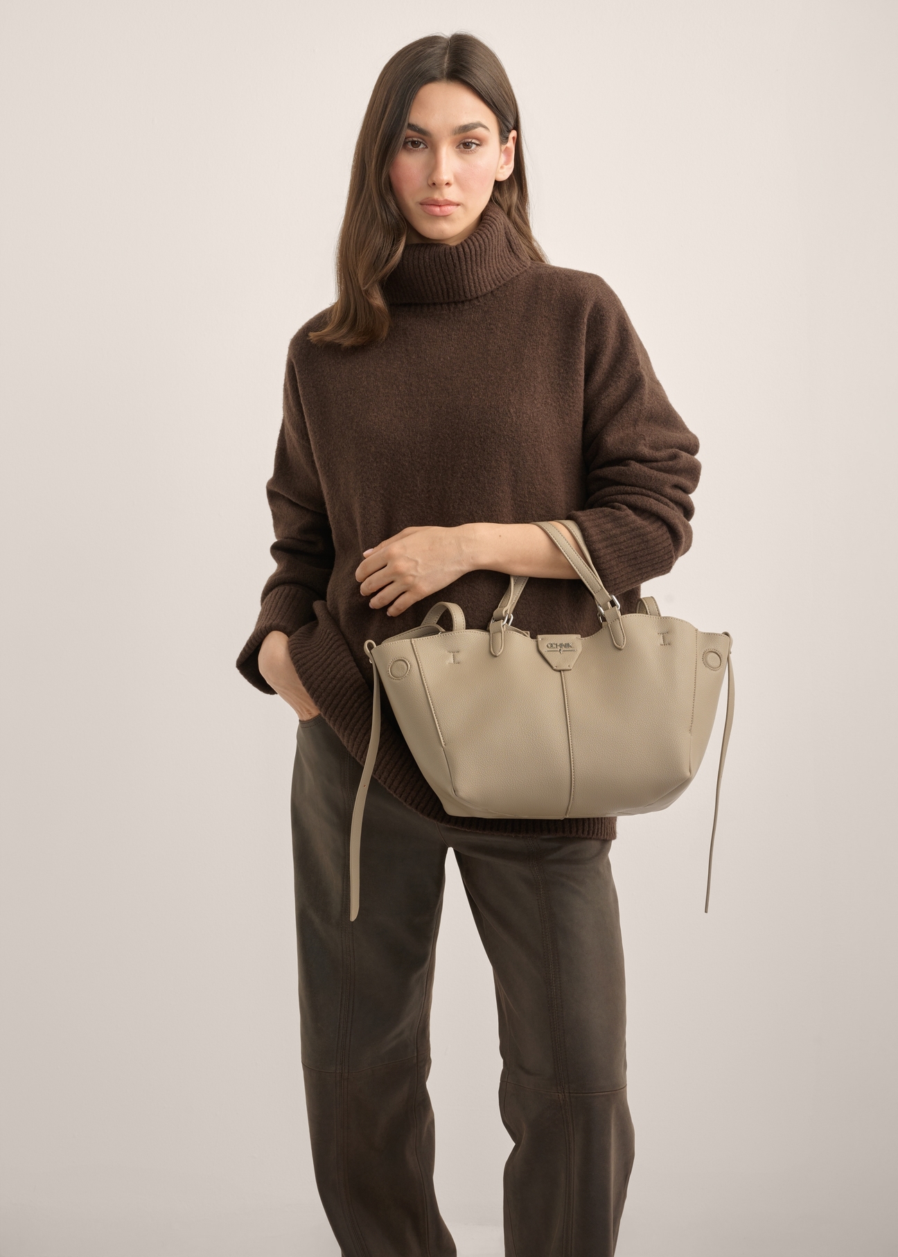 Women's dark beige handbag TOREC-1231-1K(Z26). Product view from the front on a model, half of the silhouette visible.