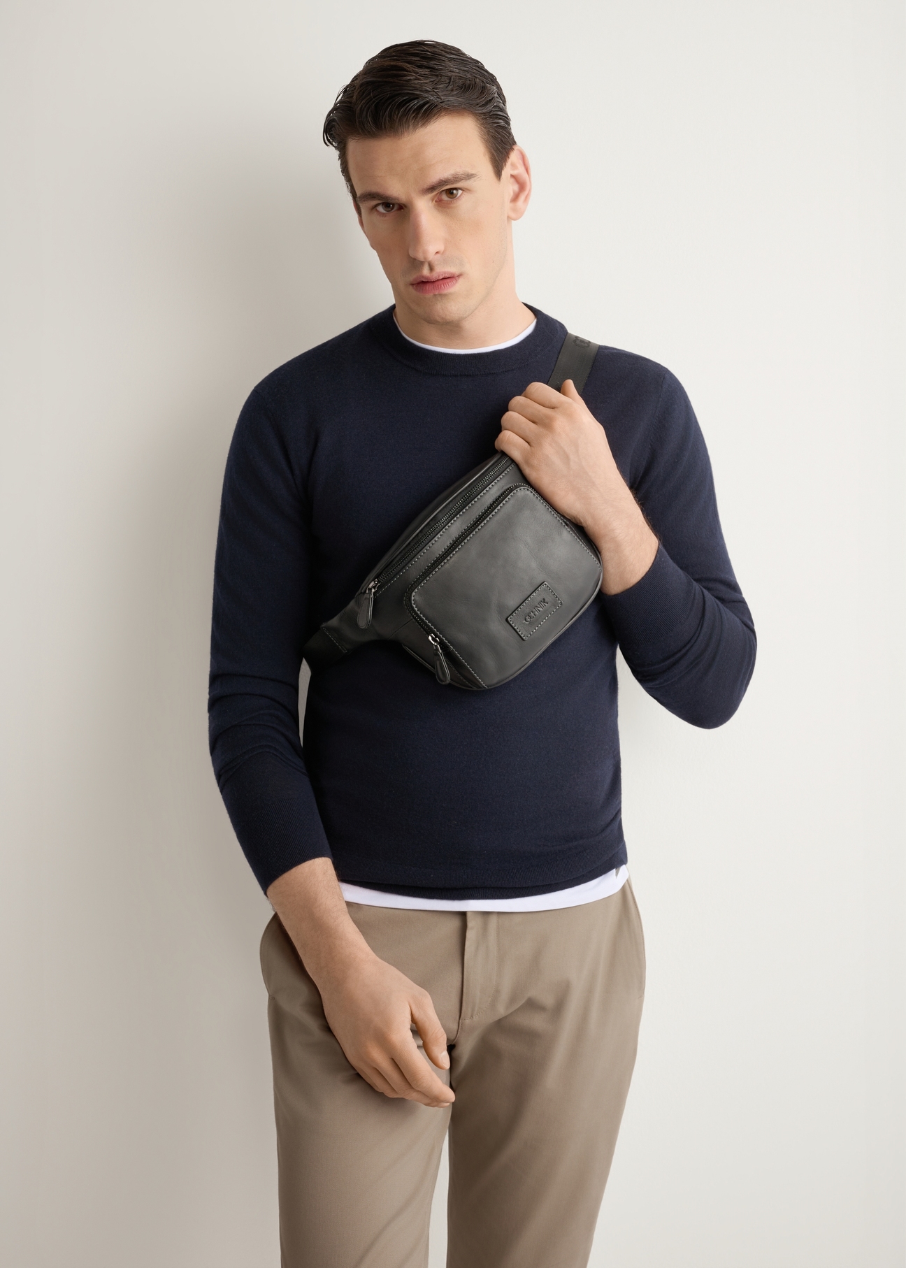 Men's black leather waist bag TORMS-0529-99(Z26) - front view of the product, on a model, on a light background.