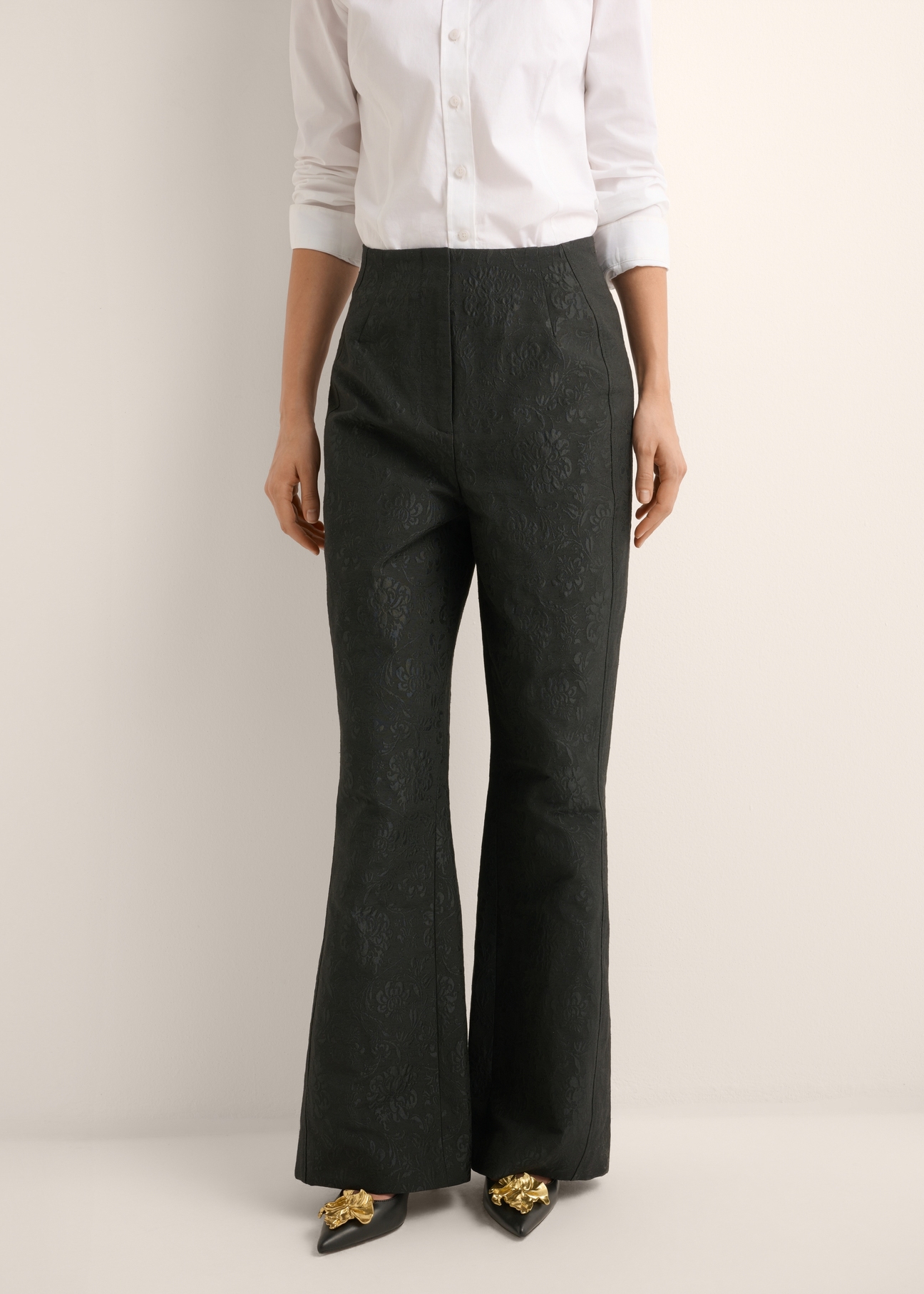 Black floral wide leg trousers SPODT-0127-99(Z26), front view of the product on the model. Half of the silhouette visible.