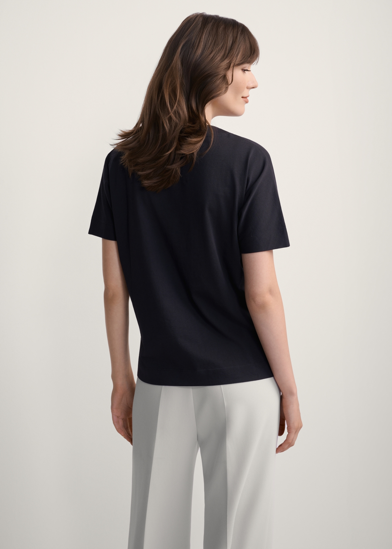 Women's black T-shirt with print TSHDT-0146-99(Z25), back view of the product on the model. Half of the silhouette visible.