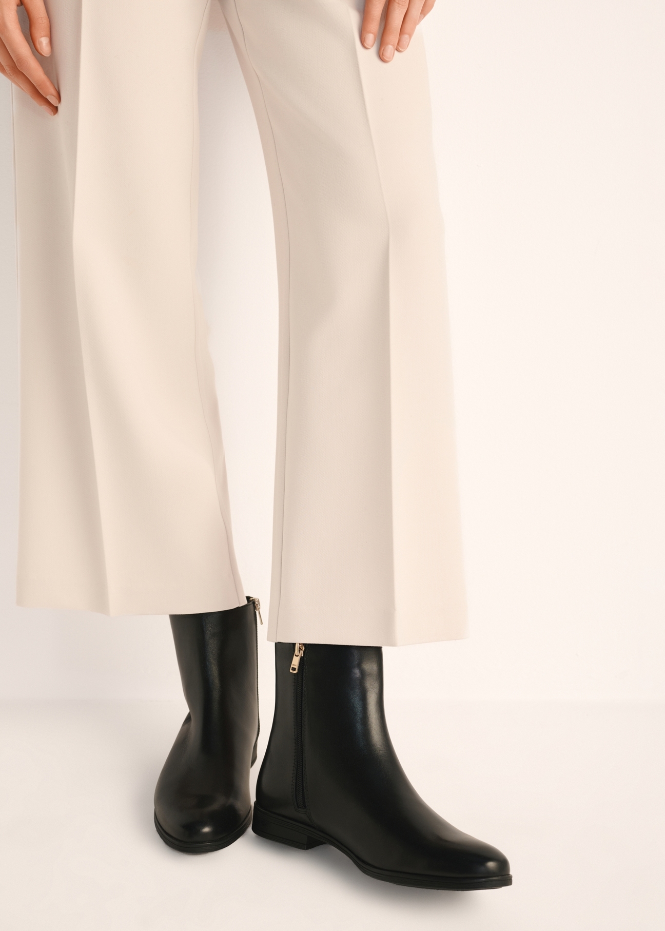 Black leather women's ankle boots BUTYD-1193-99(Z25), product view on model's feet against a light background.