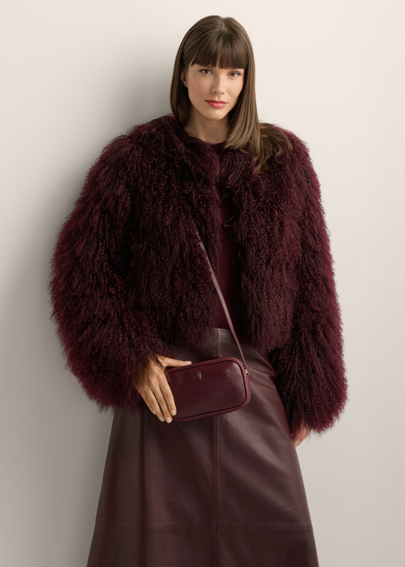 Small women's leather handbag in burgundy color TORES-1152-4D(Z26), product view on model's shoulder. Half of silhouette visible.