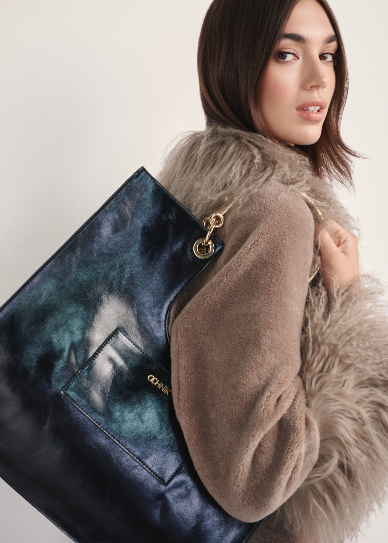 Black women's handbag TOREC-0728A-99(Z25), view of the product on the model's shoulder against a light background.