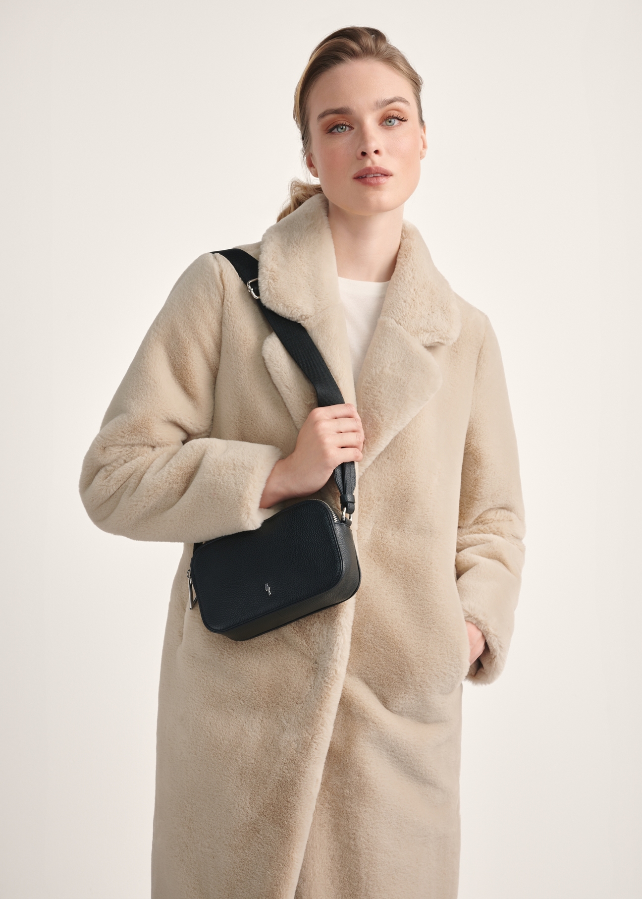 Black leather mini women's handbag TORES-1198-99(Z25), front view of the product on a model, half of the silhouette visible.
