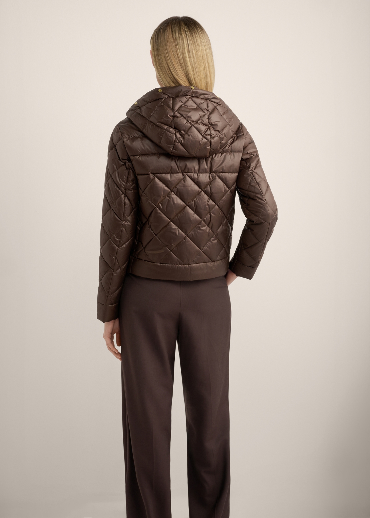 Women's brown short quilted jacket KURDT-0678-1H(Z26), back view of the product on the model. Half of the silhouette visible.