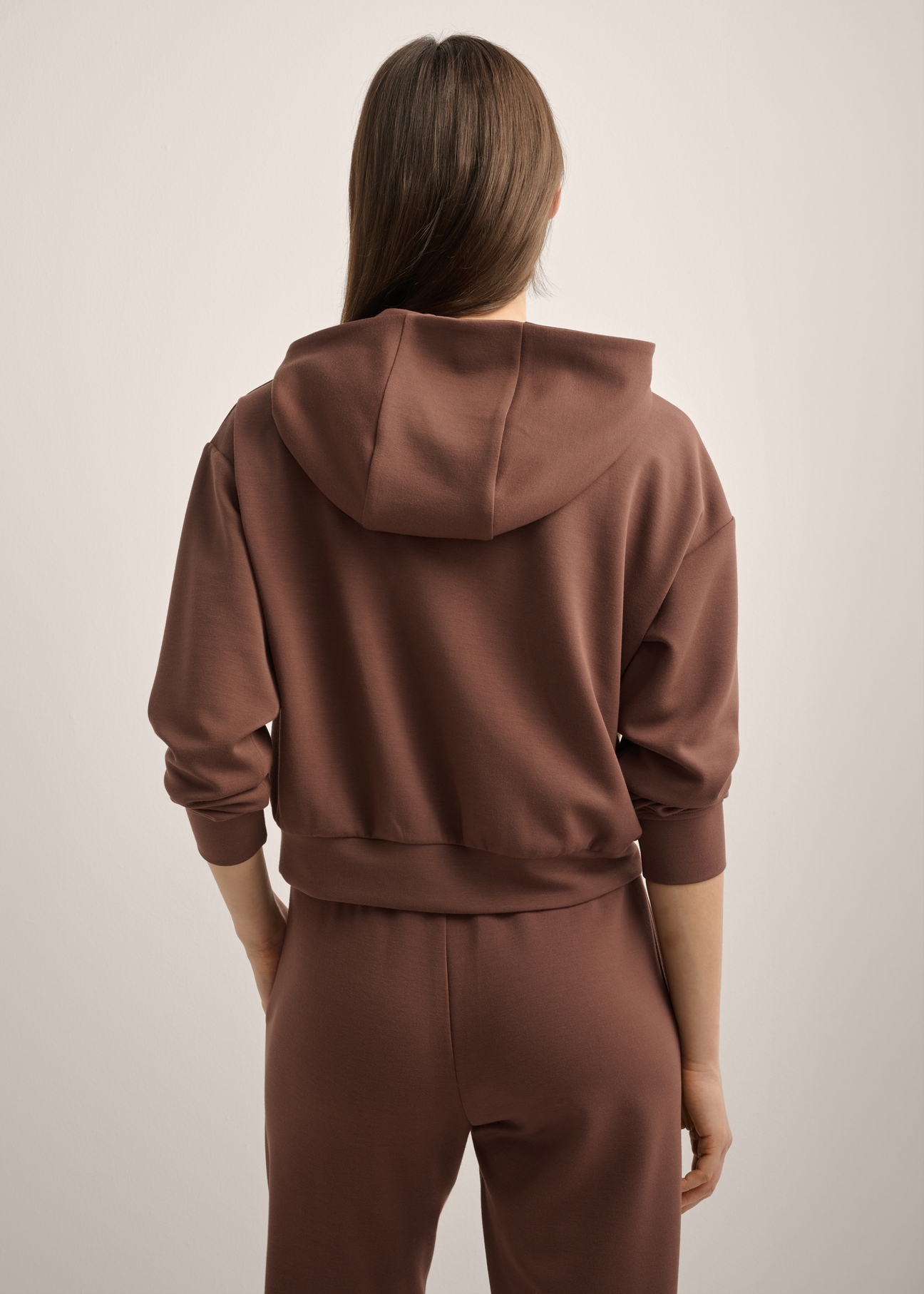 Brown women's hooded sweatshirt BLZDT-0118-1H(Z26), product view from the back on the model. Half of the silhouette visible.