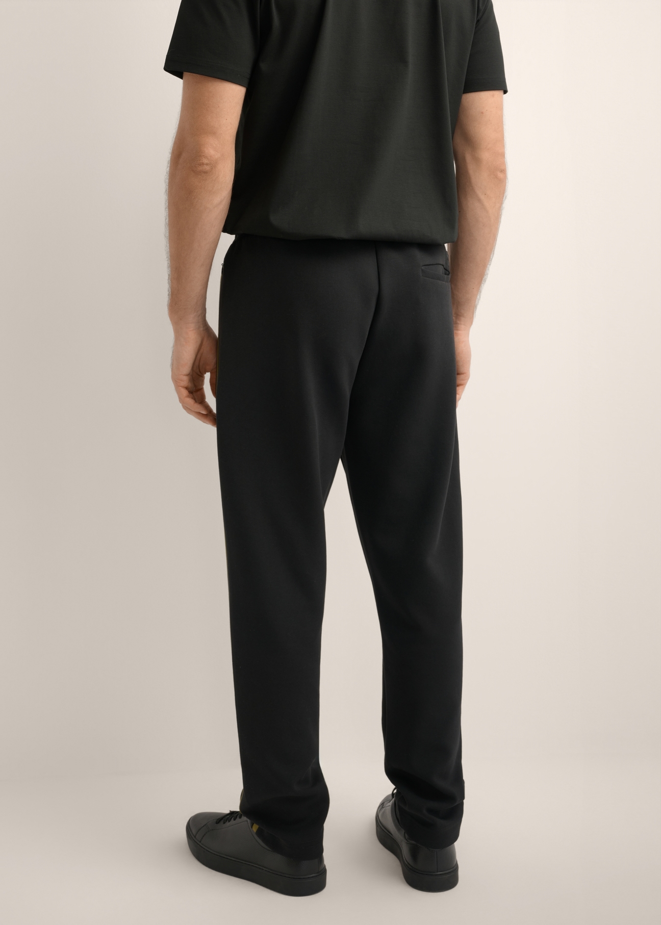 Men's black sweatpants SPOMT-0127-99(Z26), product view from the back on the model. Half of the silhouette visible.