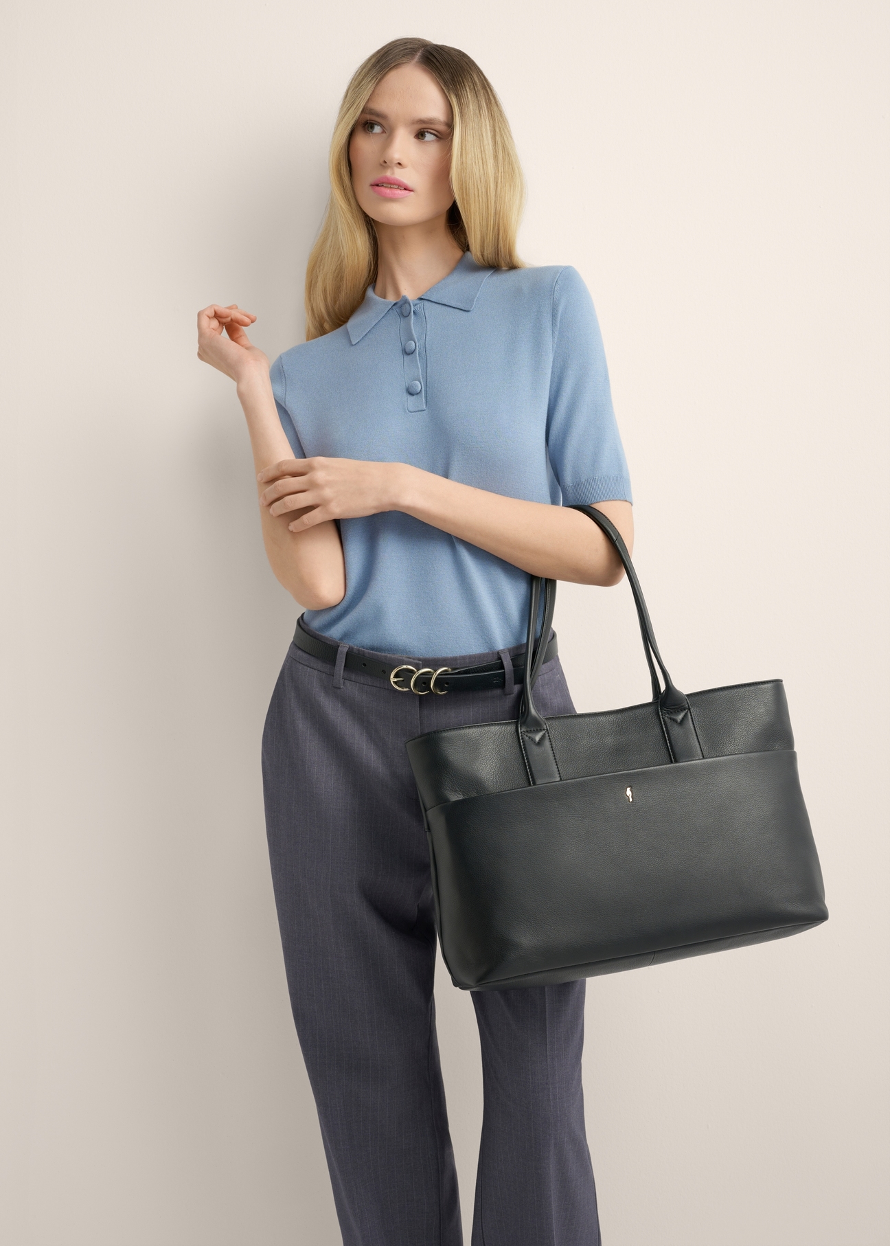 Women's leather handbag with laptop compartment TORES-1314-99(Z26), product view on model's shoulder, against a light background.