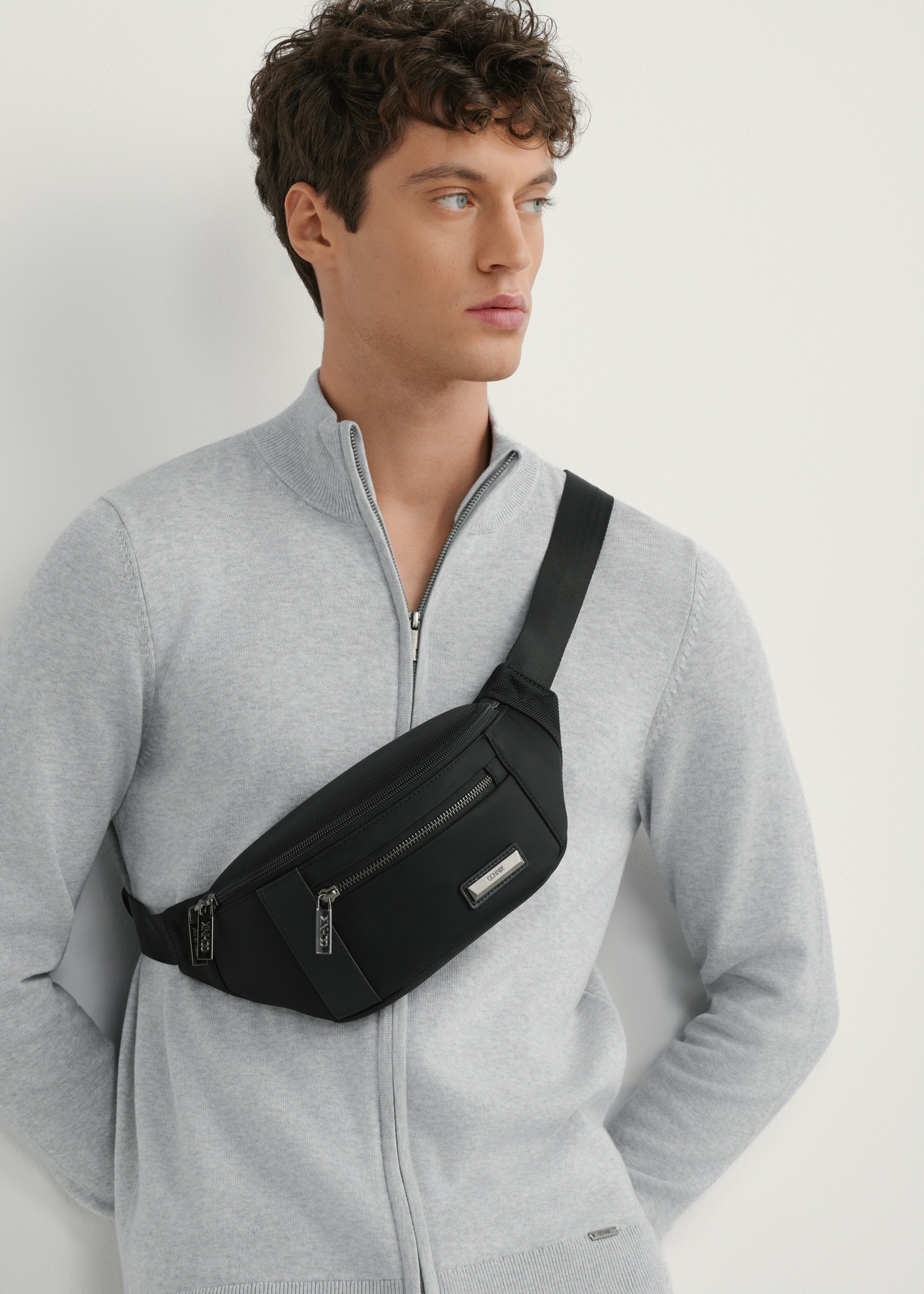 Men's black nylon waist bag TORMN-0407-99(W26), front view of the product on the model, half of the silhouette visible.