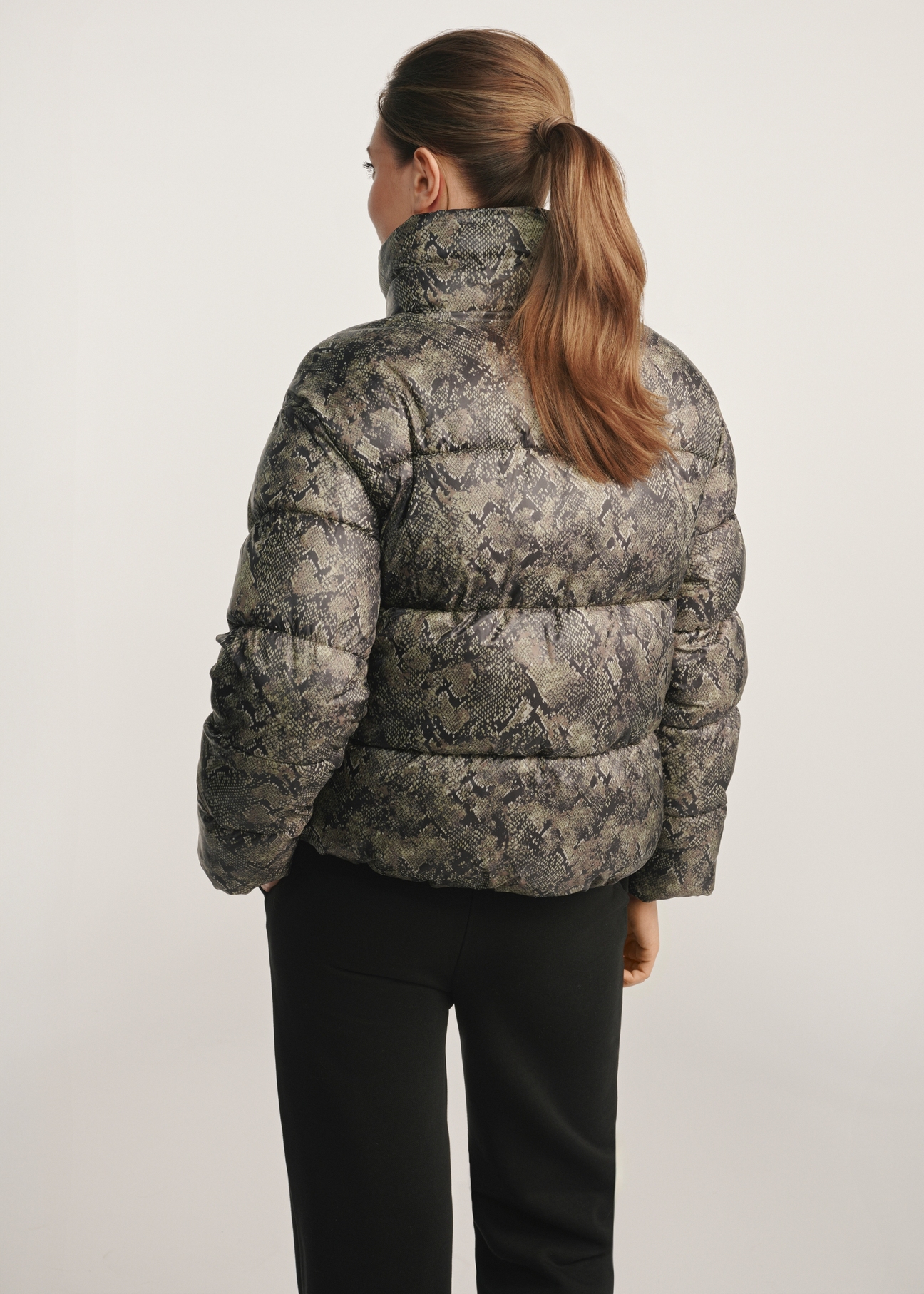 Women's snakeskin jacket KURDT-0598-54(Z25), back view of the product on the model. Half of the silhouette visible.