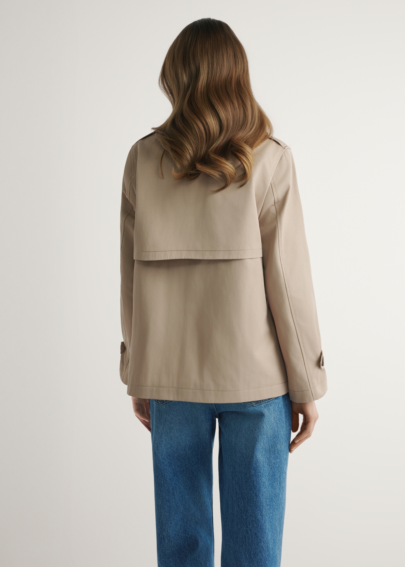 Beige women's short jacket KURDT-0556-1C(W26), back view of the product on the model. Half of the silhouette visible.