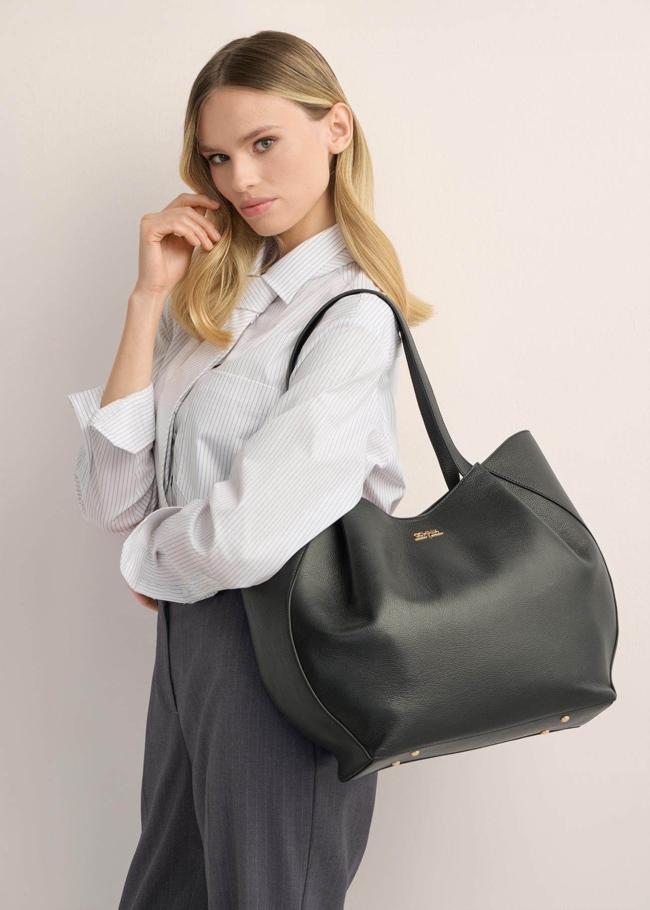 Women's black leather shopper bag TORES-1358-99(Z26), product view on model's shoulder. Half of silhouette visible.