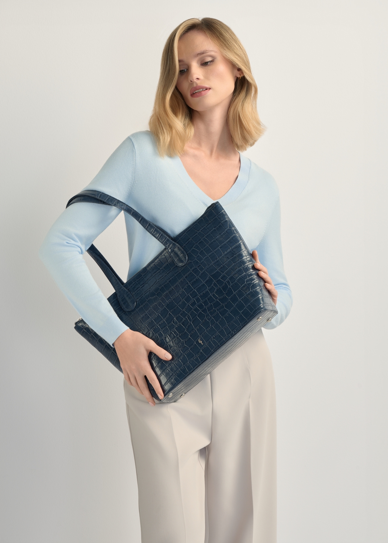 Women's navy blue leather shopper bag TORES-0939F-7D(W26), product view on model's shoulder. Half silhouette visible.