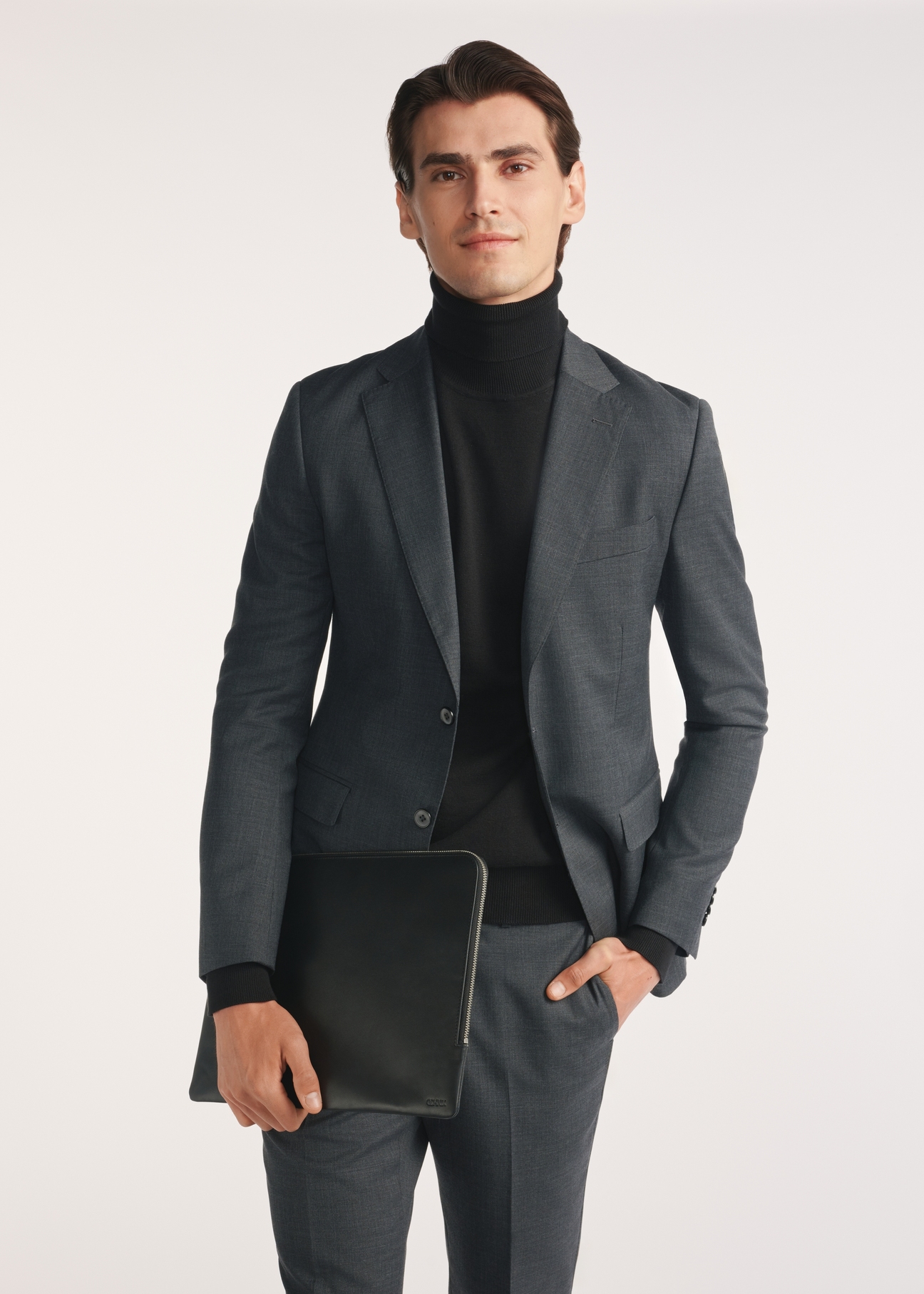 Black men's briefcase TORMS-0474-99(Z25), diagonal view of the product on the model, half of the silhouette visible.