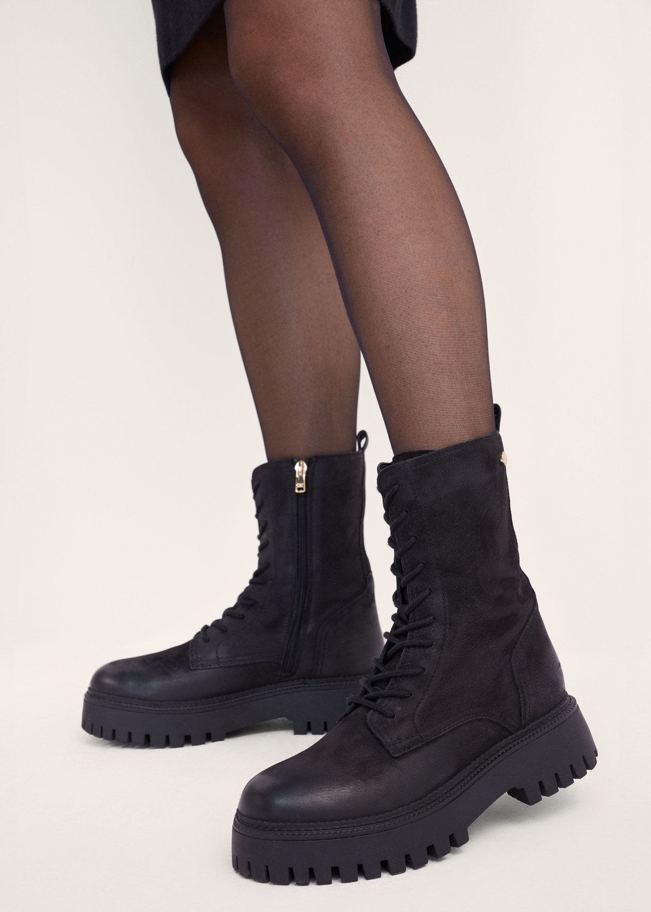 Women's leather ankle boots in combat boot style BUTYD-1004-9I(Z26), side view of the product on the model's feet.