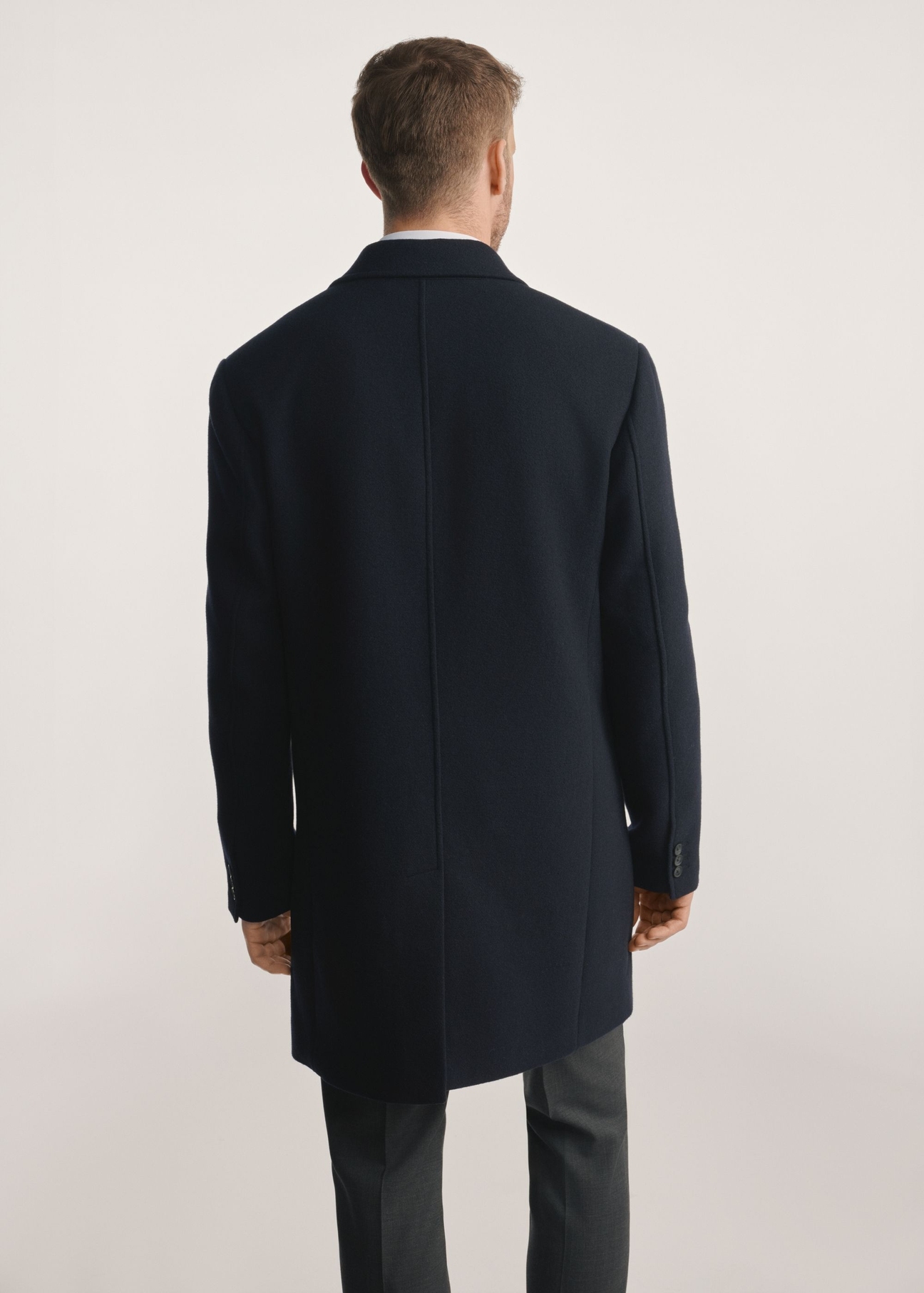 Navy blue men's coat PLAMT-0006-69(Z25), product visible from the back on the model, half of the silhouette visible.