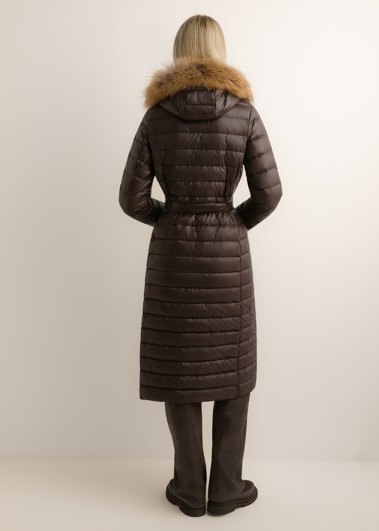 Dark brown long women's jacket with fur KURDT-0706-1I(Z26), back view of the product on the model. The entire silhouette is visible.