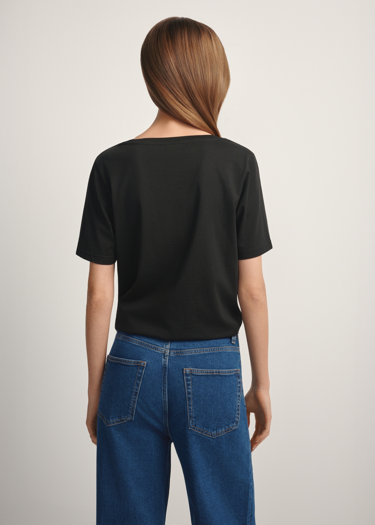 Black basic women's T-shirt TSHDT-0120-99(W25), product view from the back on the model, half of the silhouette visible.