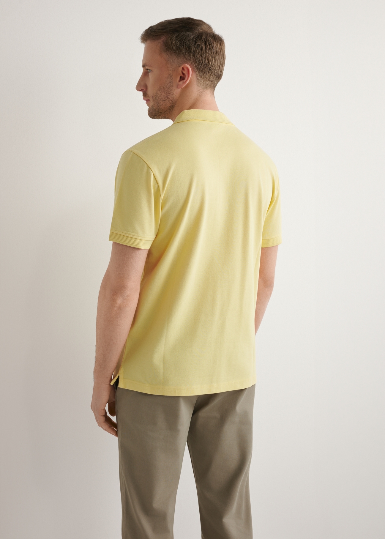 Men's yellow polo shirt POLMT-0089-2B(W26), back view of the product on the model. Half of the silhouette visible.