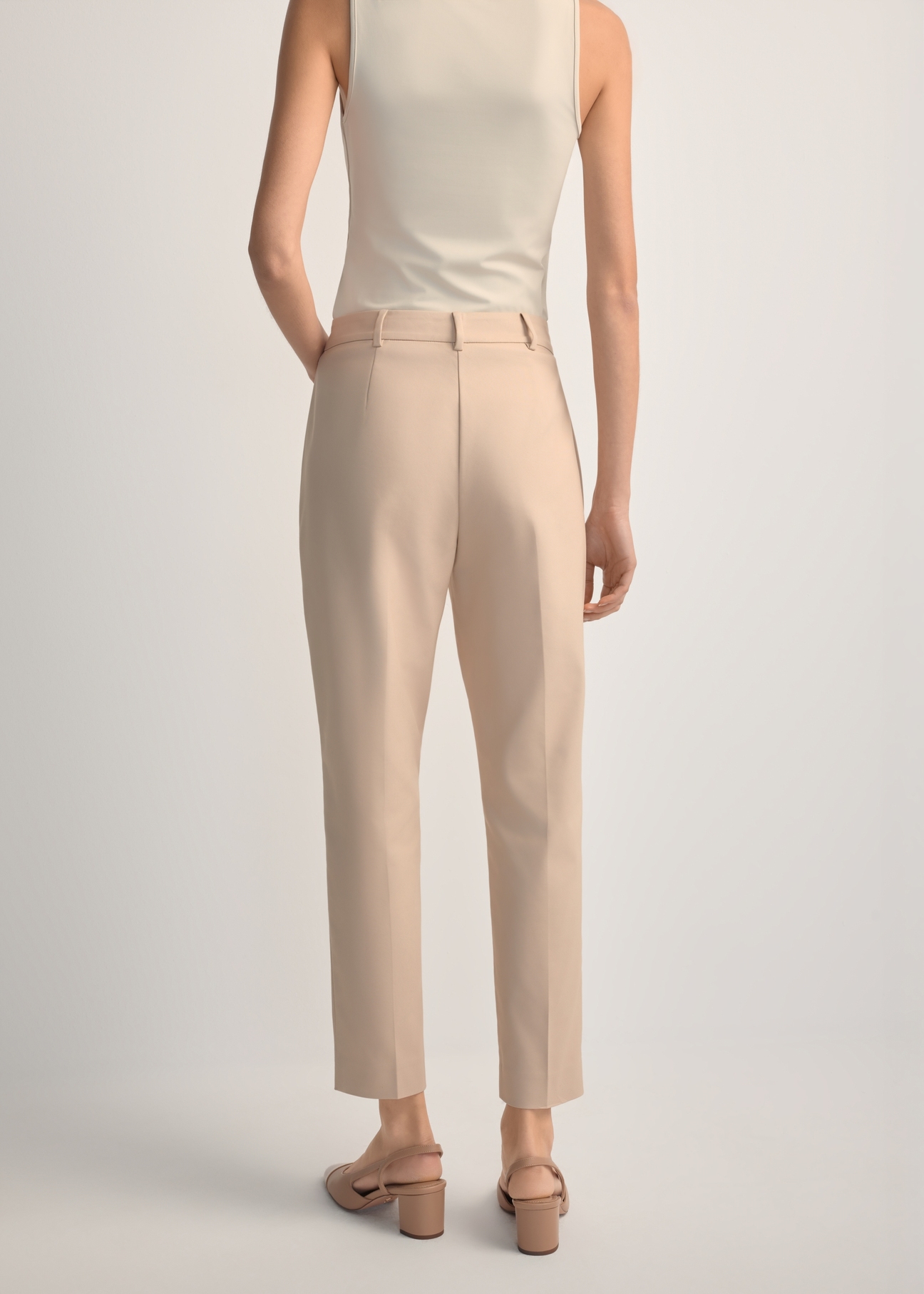 Beige women's pleated trousers SPODT-0090-1B(W26), back view of the product on the model. Half of the silhouette visible.
