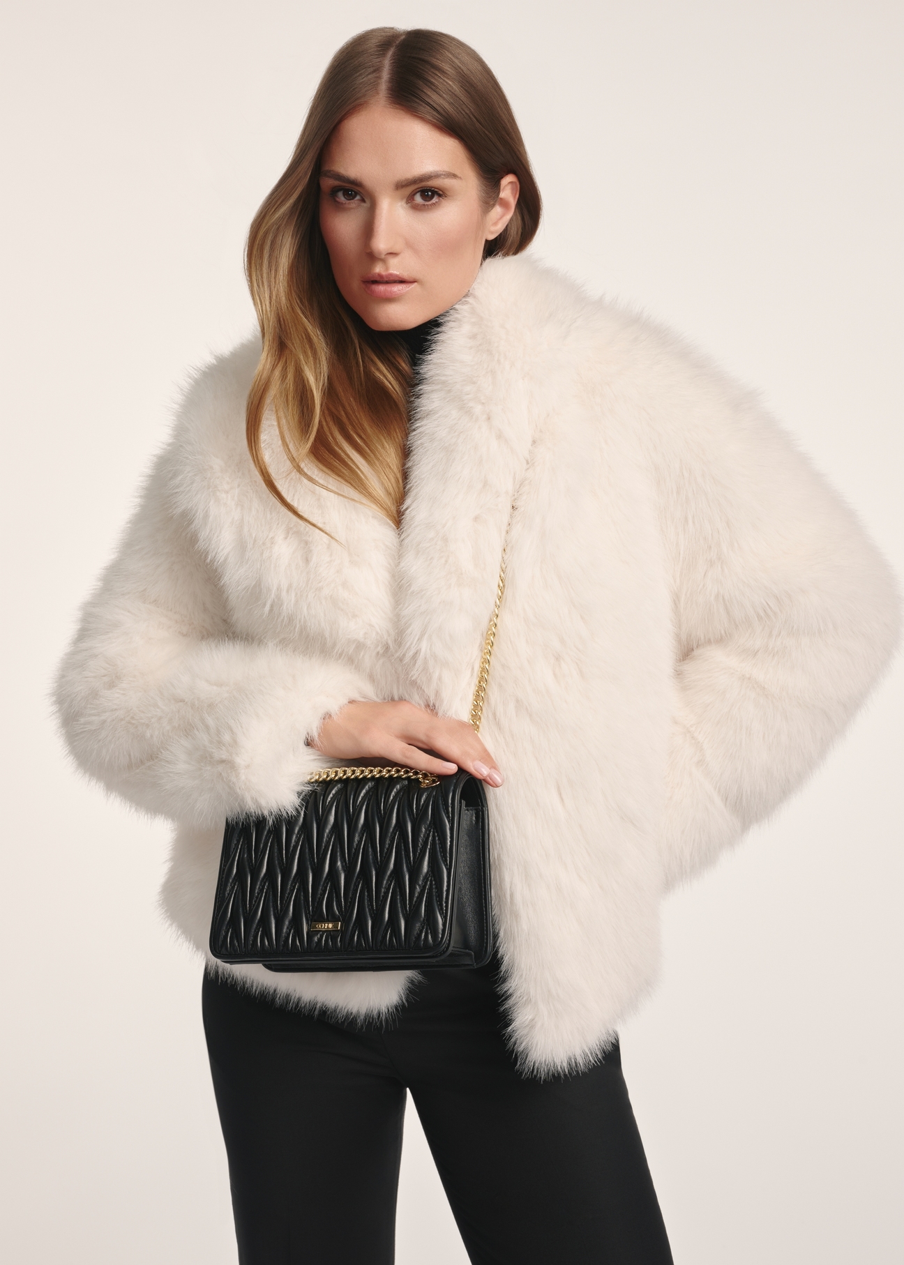 Black women's handbag with chain TOREC-1102-99(Z25), product view on a model. Half of the silhouette visible.