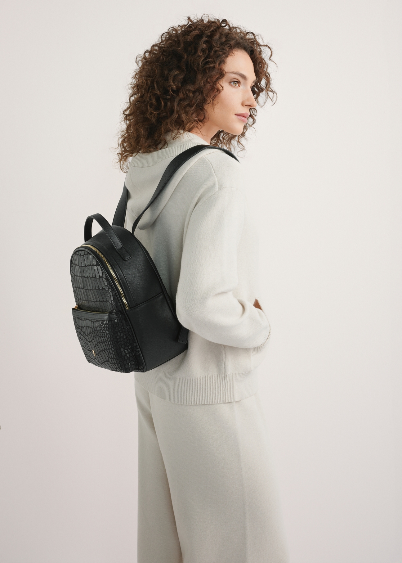 Black medium women's croco backpack TOREC-0920-9G(W26), product view on model's back. Half of silhouette visible.