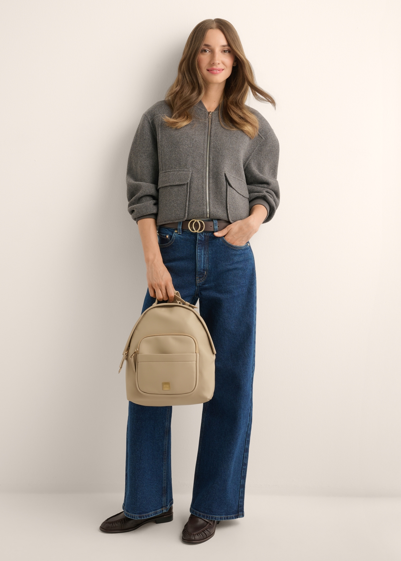 Beige women's backpack TOREC-1253-1B(Z26), product view in model's hand. Full body visible.