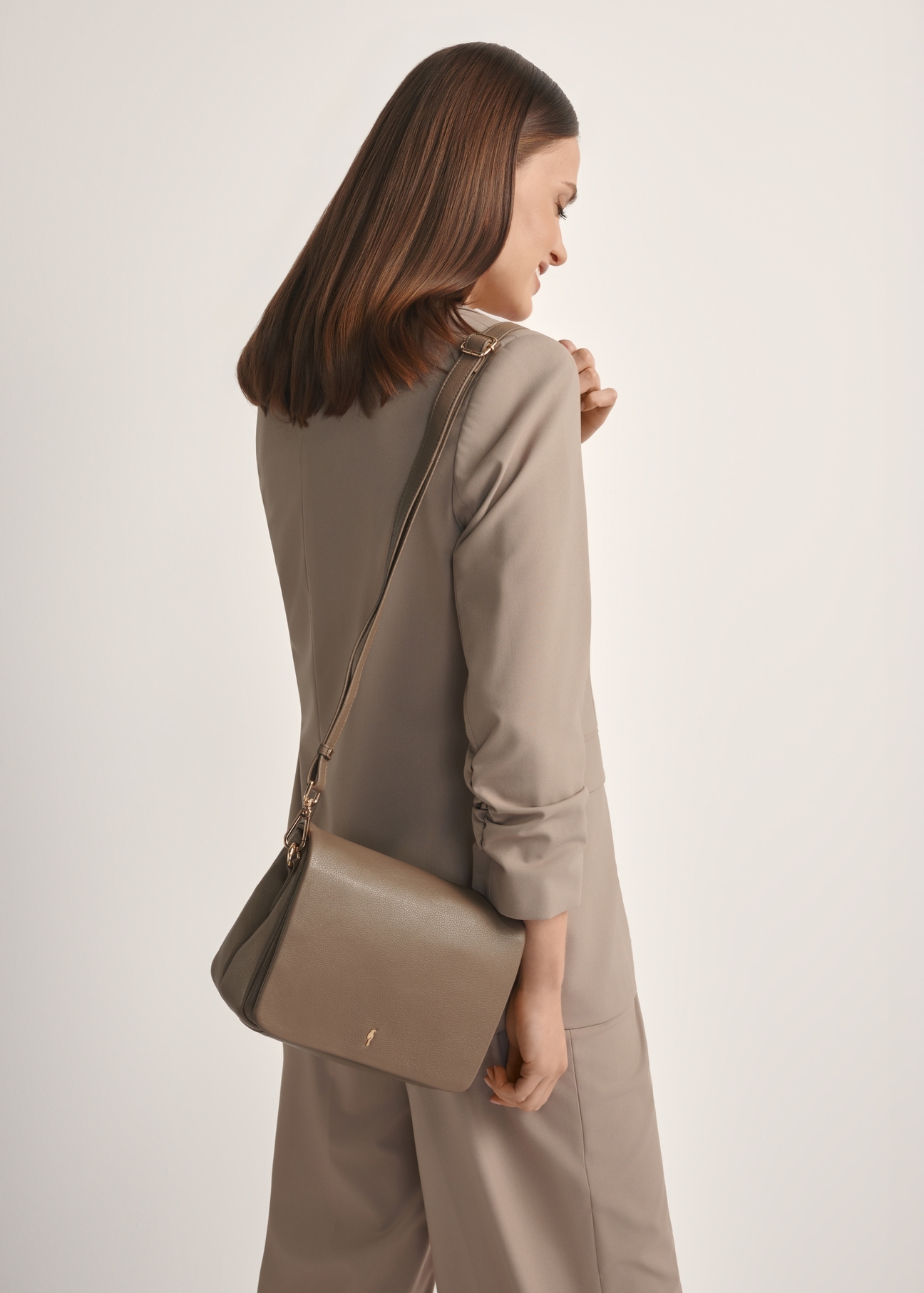 Dark brown leather women's handbag TORES-0911 F-1K(W26), front view of the product on a model, half of the silhouette visible.