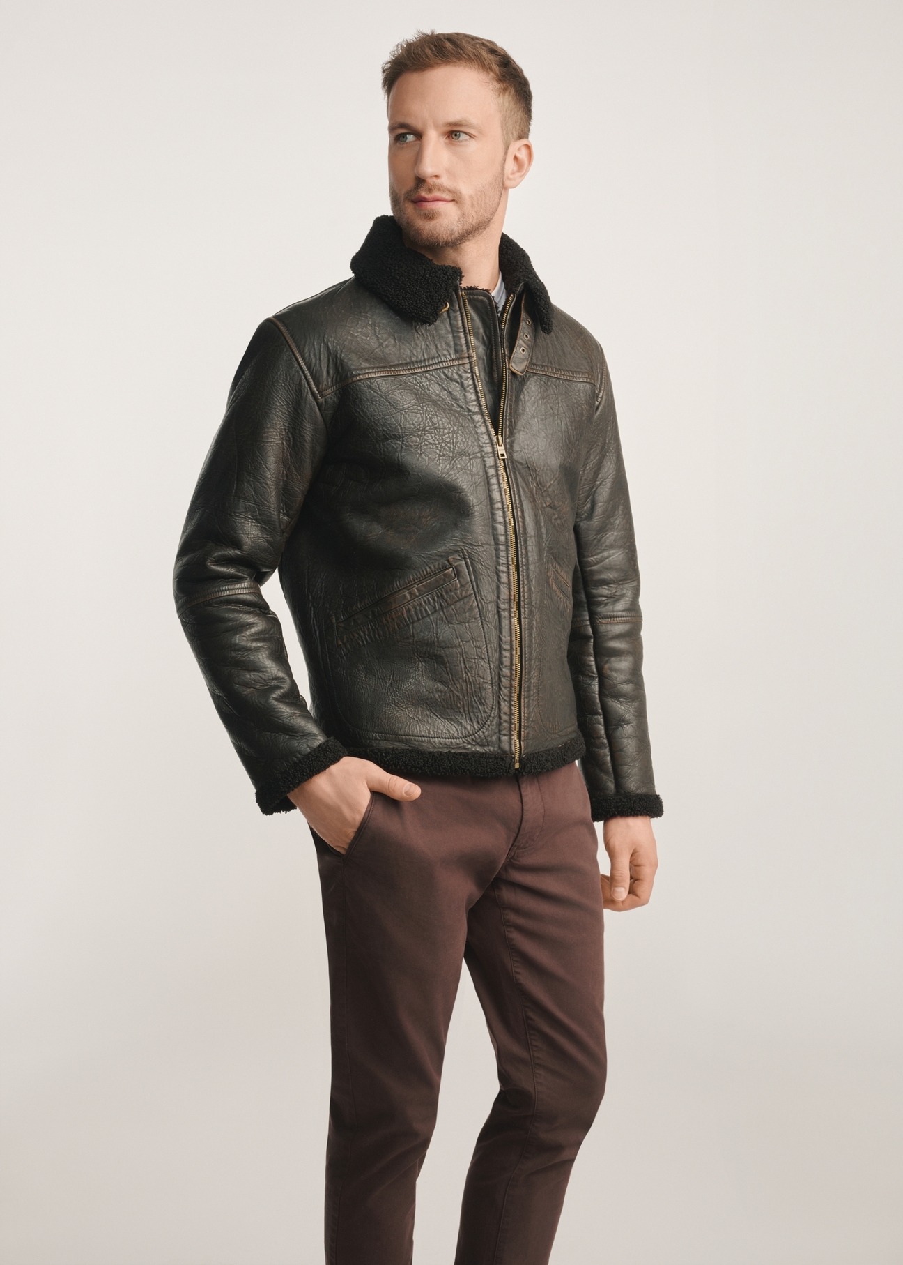 Brown men's leather jacket with sheepskin KURMS-0386-0704(Z25), diagonal view of the product on the model, half of the silhouette visible.
