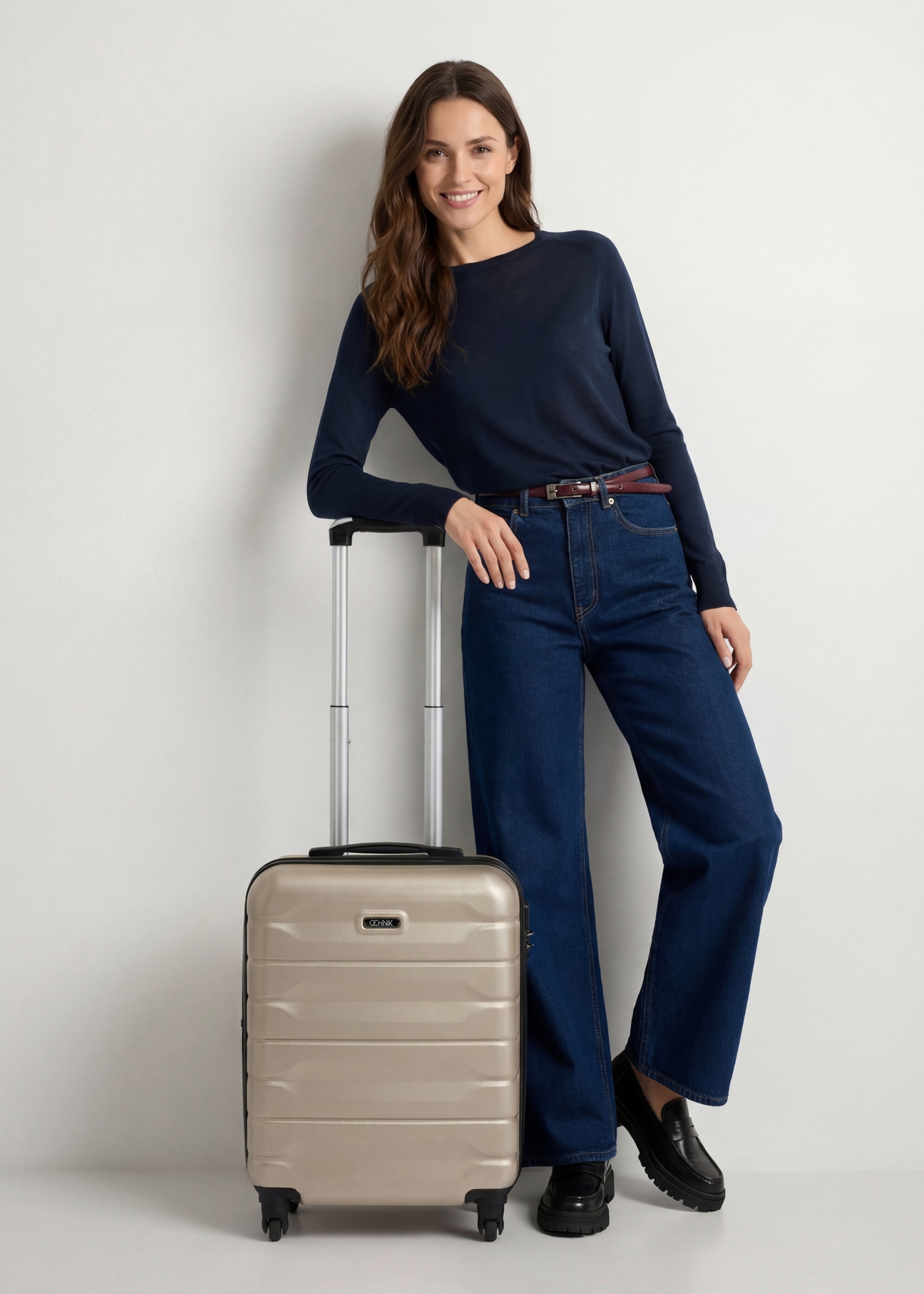 Small suitcase on wheels WALAB-0067-0X-19(W26), product view from the front next to the model, the entire silhouette is visible.