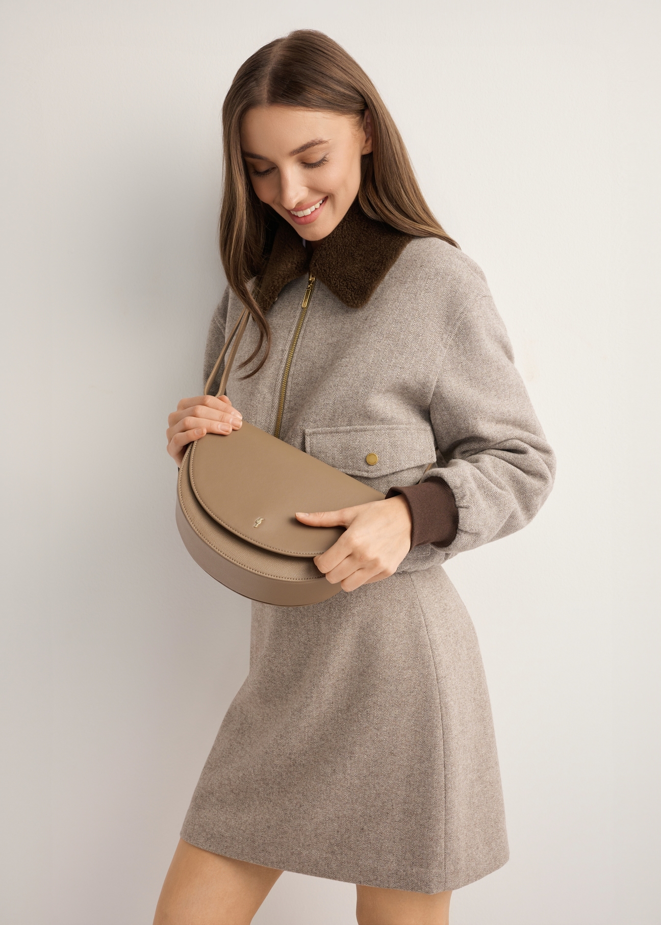 Beige semi-circular women's messenger bag TOREC-1298-1B(Z26), front view of the product on the model. Half of the silhouette visible.