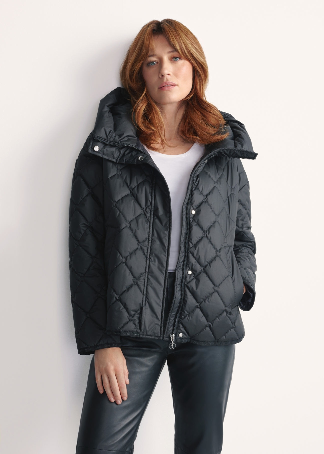 Black women's quilted jacket with hood KURDT-0588-99(Z25), front view of the product on a model, half of the silhouette visible.