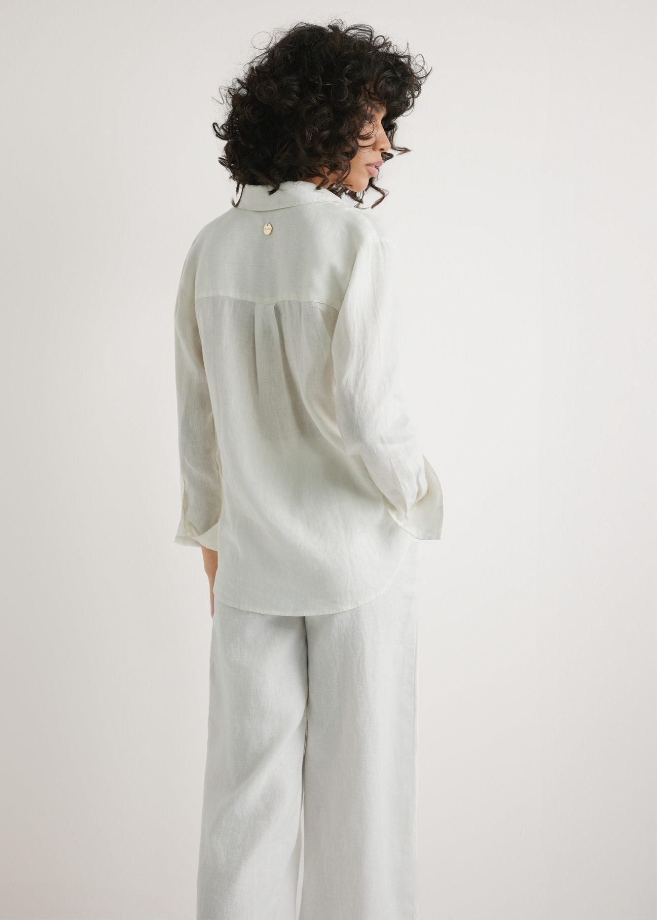Women's white linen shirt KOSDT-0163A-0B(W26) - back view of the product, on a model, against a light background. Half of the silhouette visible.