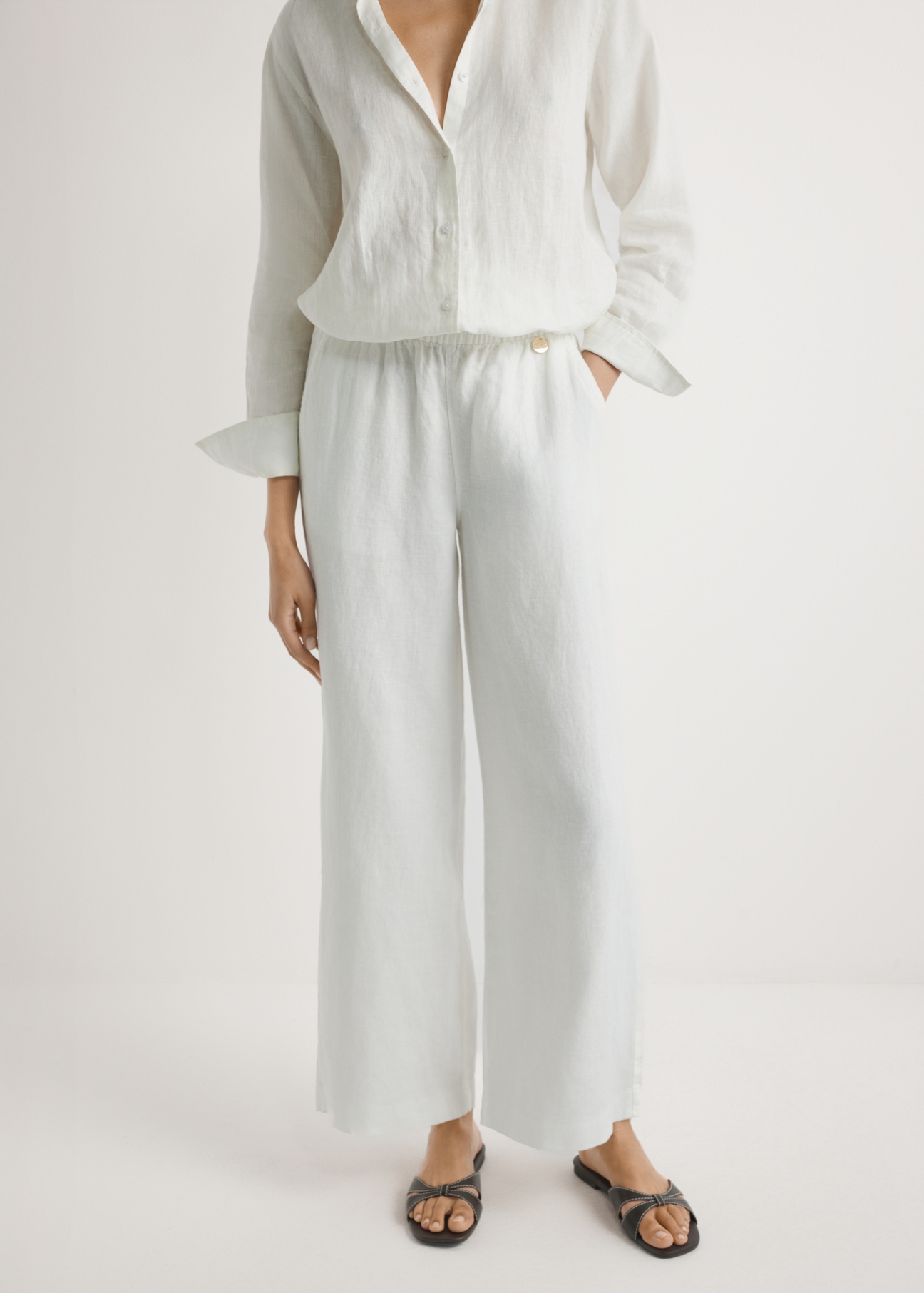 Light beige linen women's trousers SPODT-0124-1A(W26), front view of the product on the model, half of the silhouette visible.