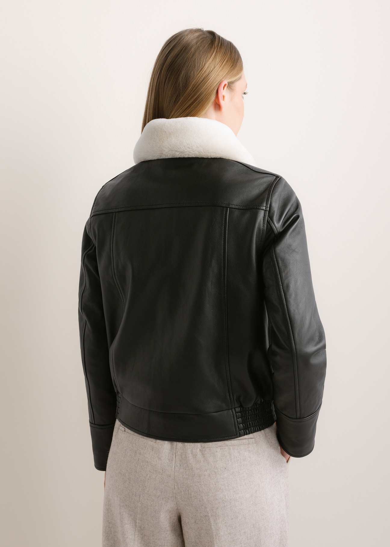 Black leather bomber jacket KURDS-0646-99(Z26), rear view on a model. Half-body shot.