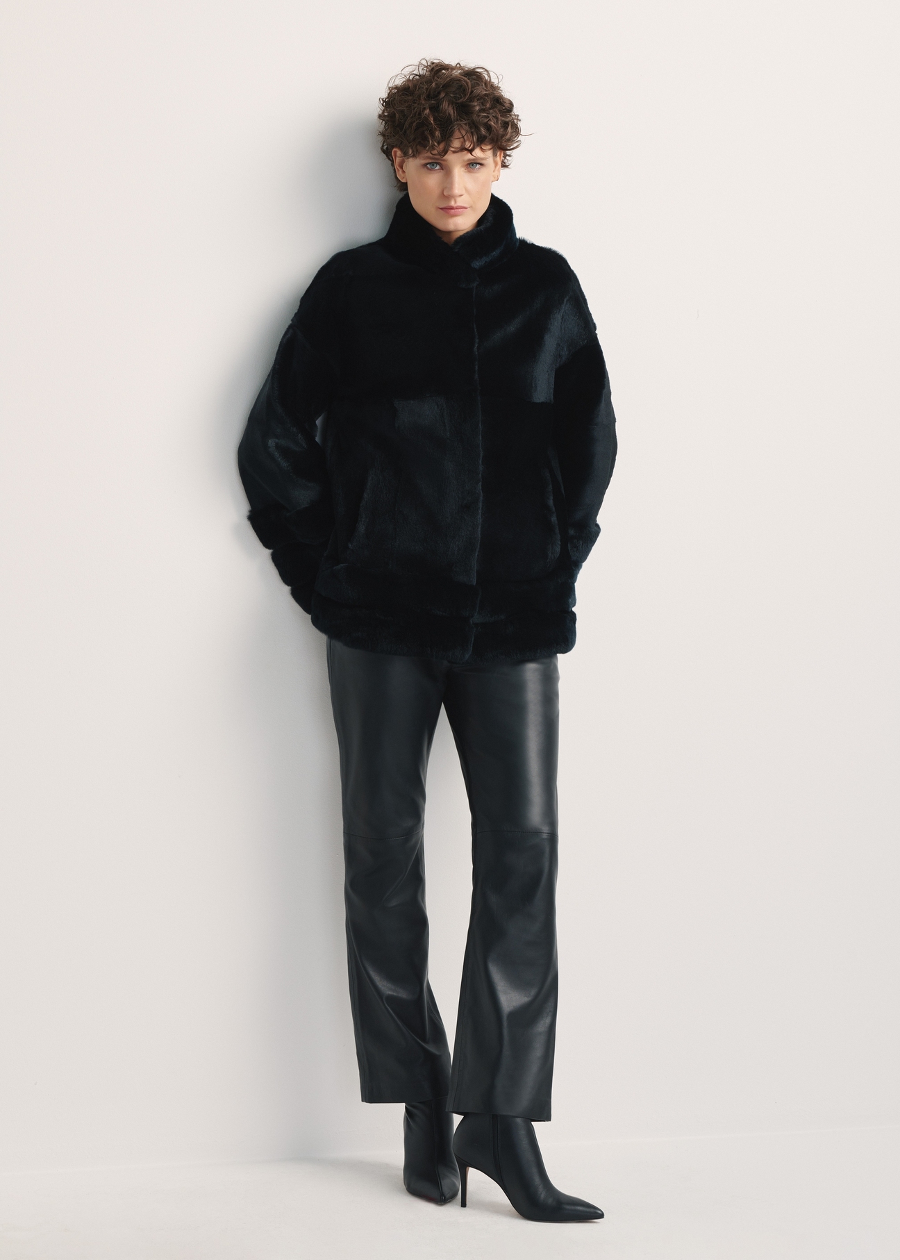 Black women's fur coat with a stand-up collar, natural FUTDF-0077-0984(Z24), front view of the product on a model, the entire silhouette is visible.