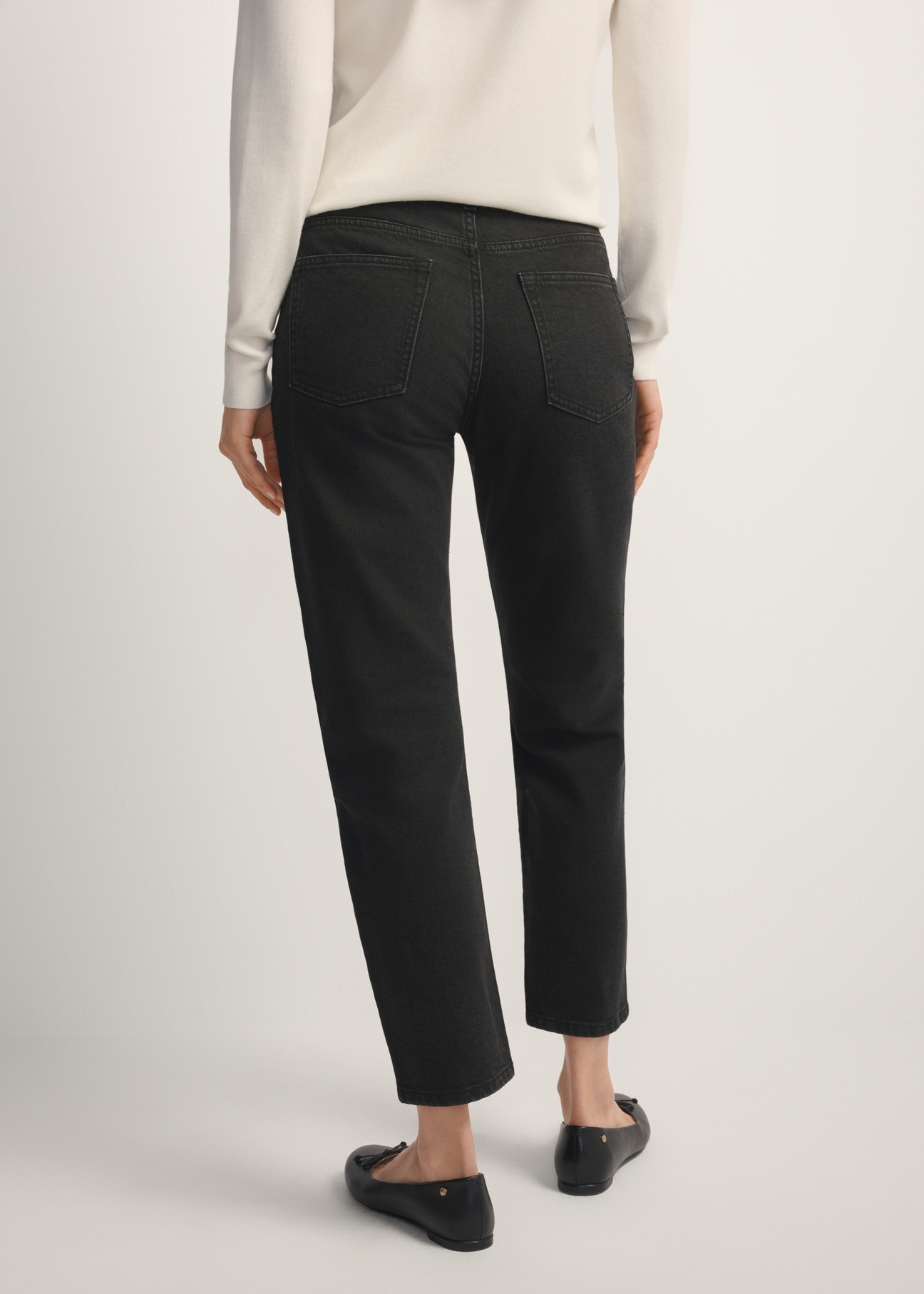 Women's black denim jeans JEADT-0011-99(W26), back view of the product on the model. Half of the silhouette visible.