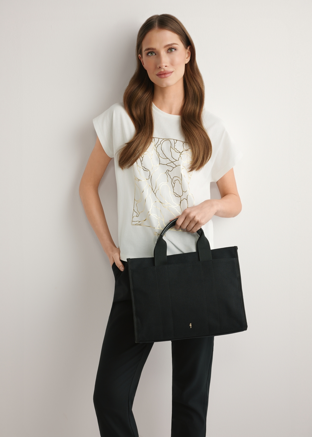 Black cotton women's handbag TOREN-0332-99(W26), product view in model's hand. Half of silhouette visible.