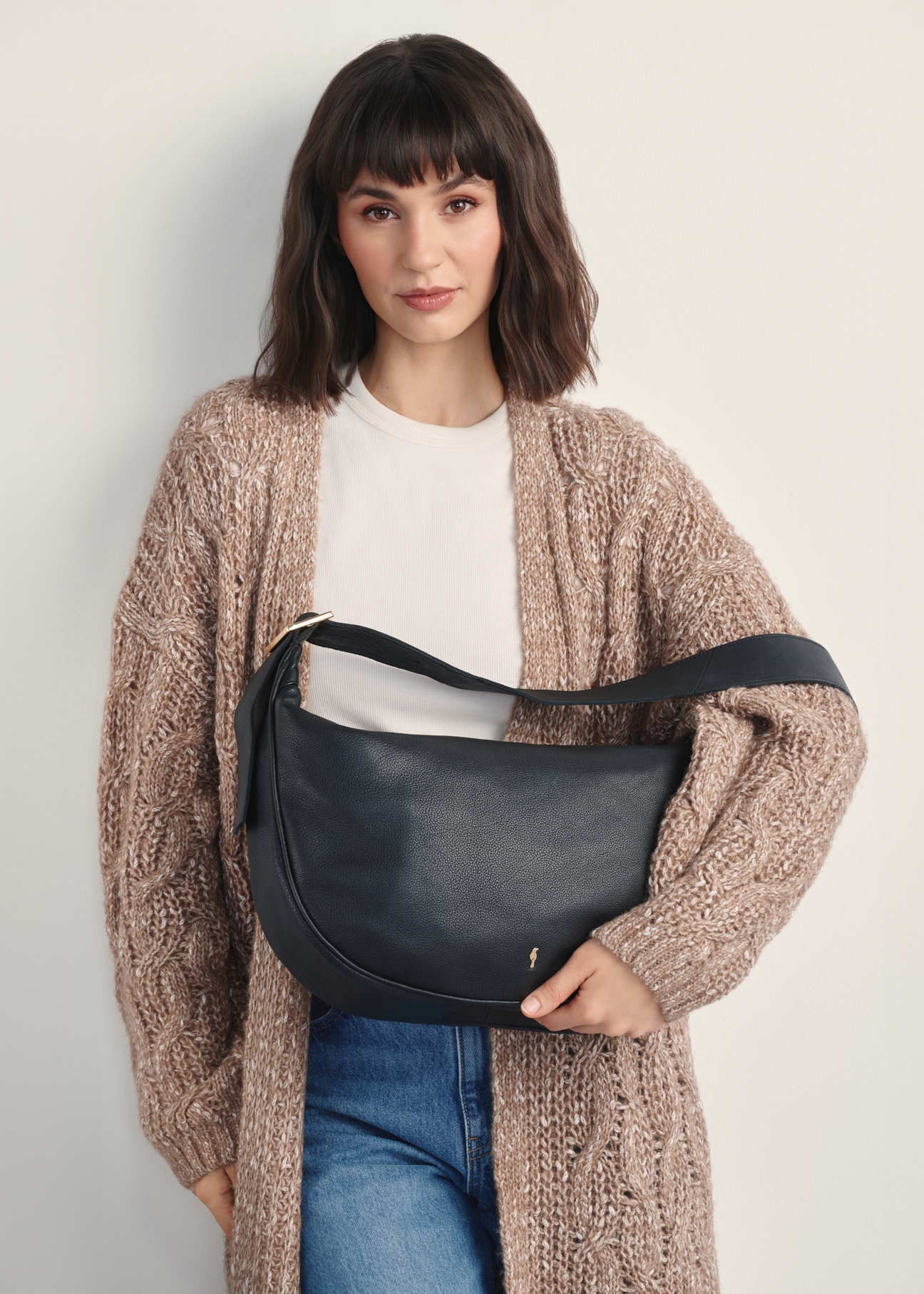Black leather shoulder bag TORES-1127E-99(Z25), front view of the product on a model, half of the silhouette visible.