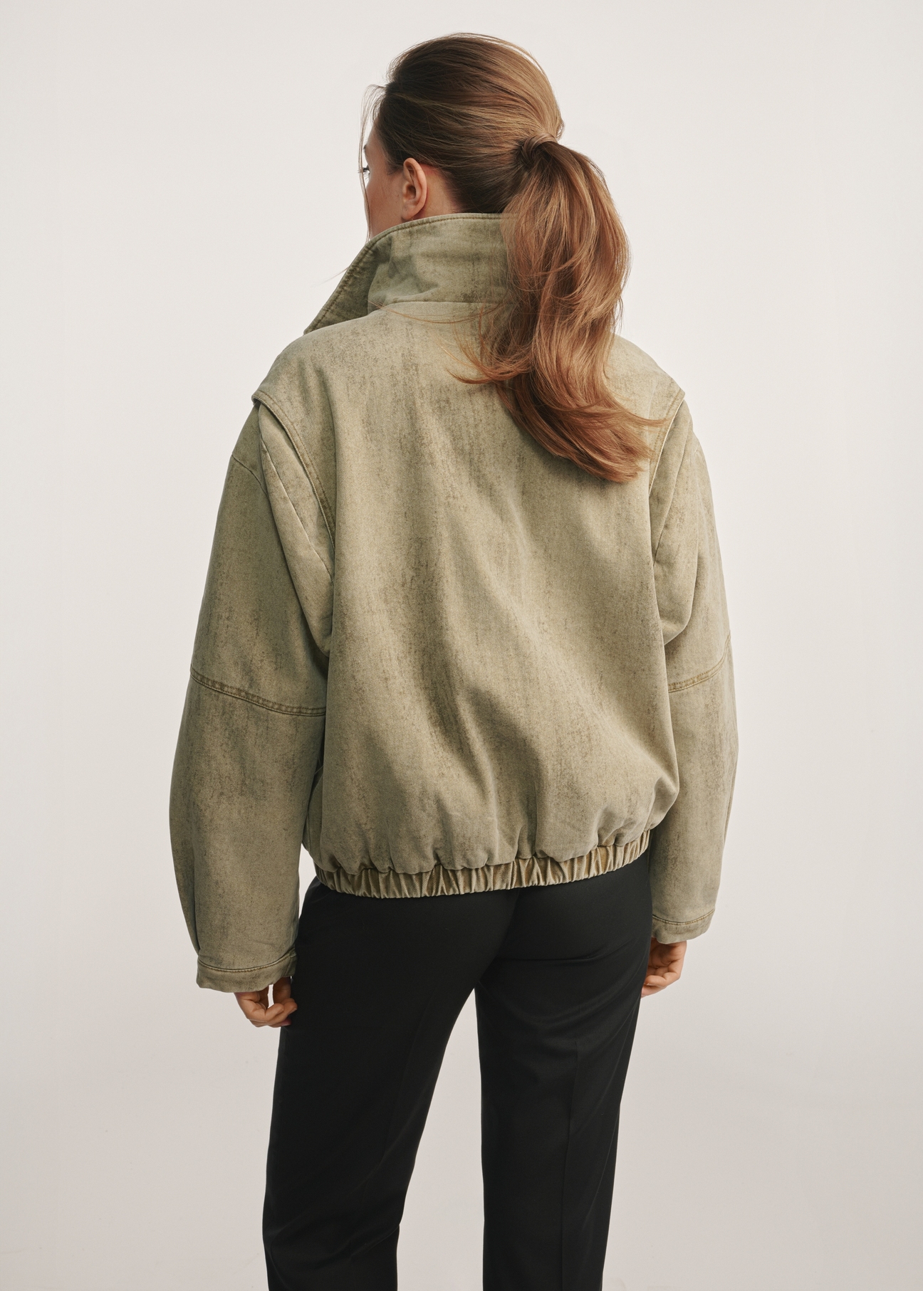 Women's olive green fur jacket KURDT-0611-57(Z25) - back view of the product against a white background. Knee-length silhouette visible.