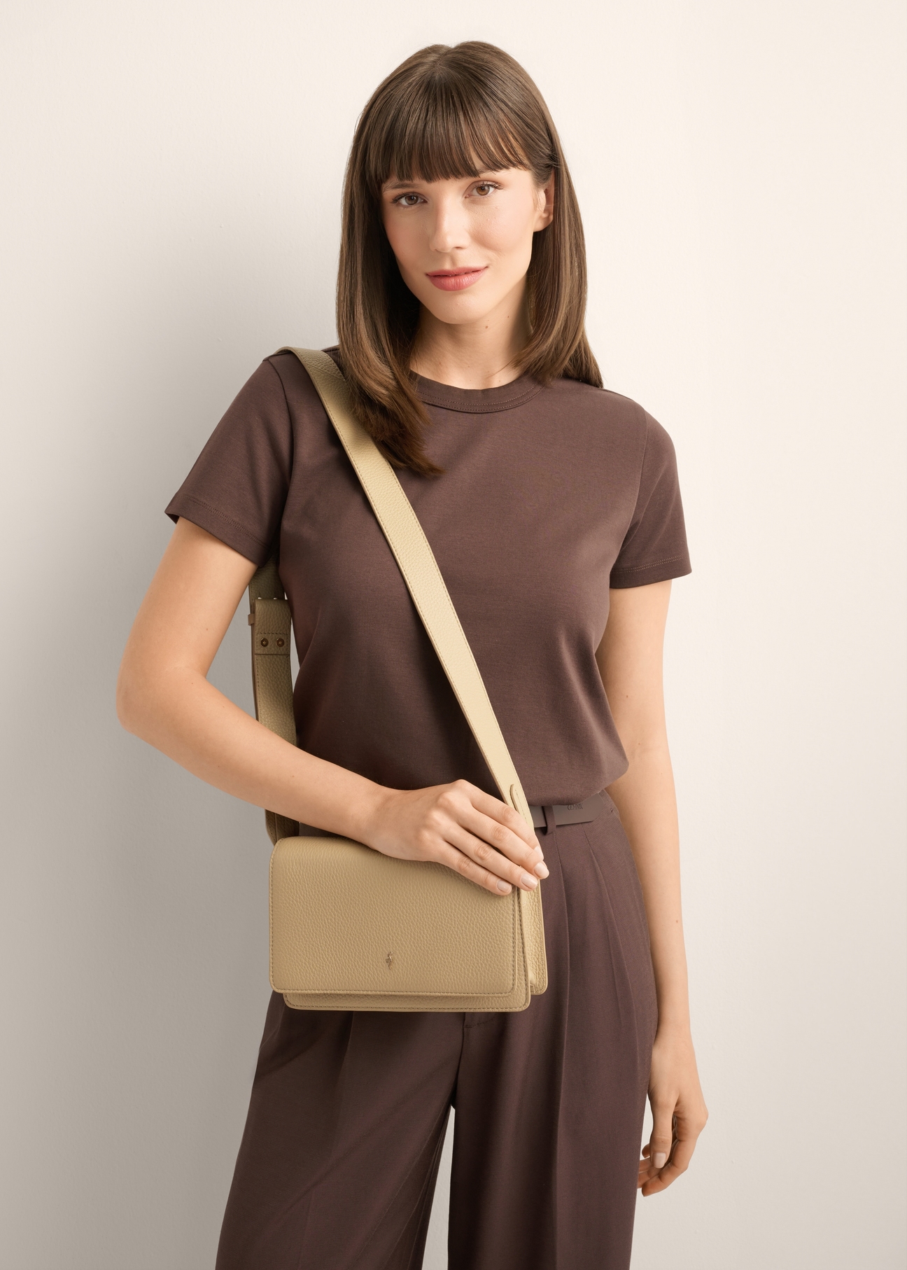 Beige elegant leather women's handbag TORES-1356-1B(Z26), front view of the product on the model's shoulder, on a light background.