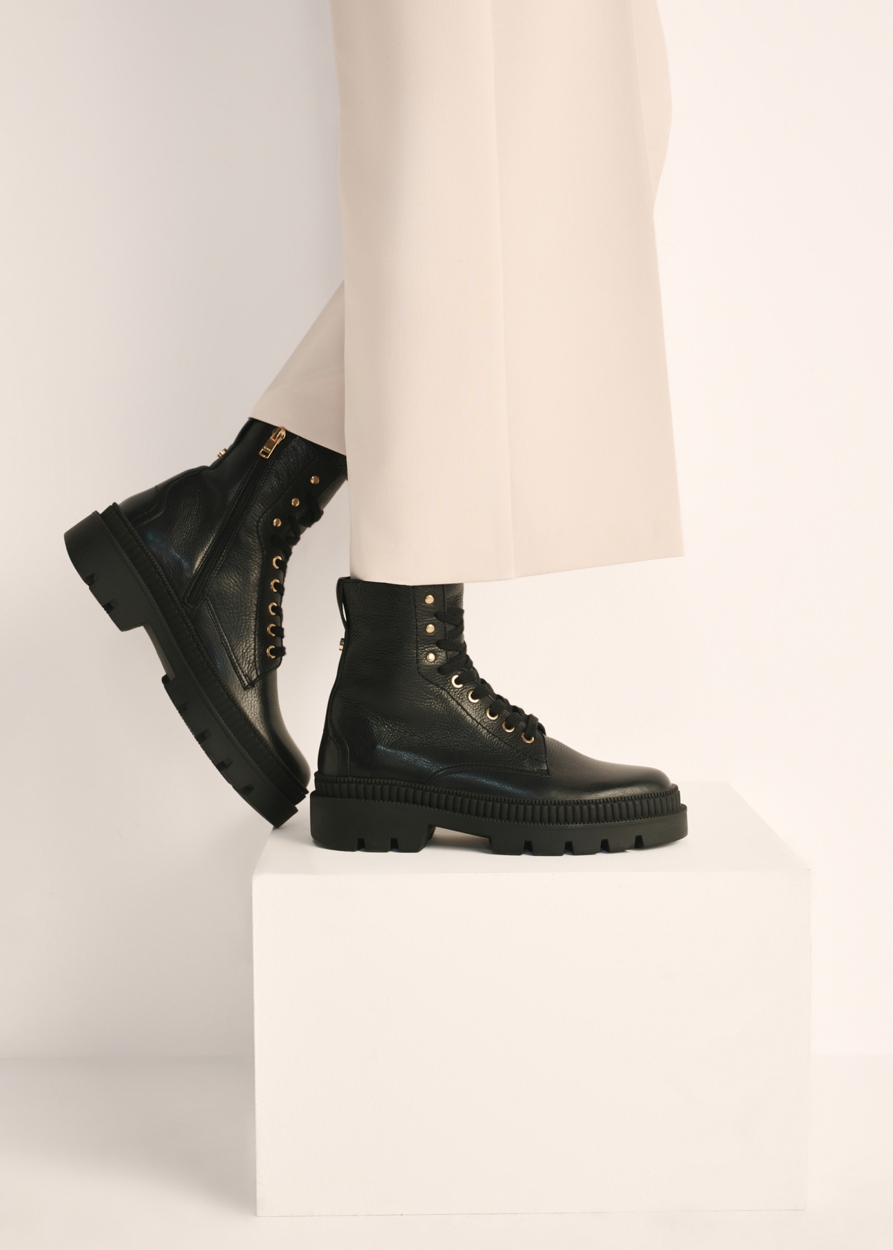 Black leather insulated women's ankle boots BUTYD-1103-99(Z25), product view on the model's feet against a light background.