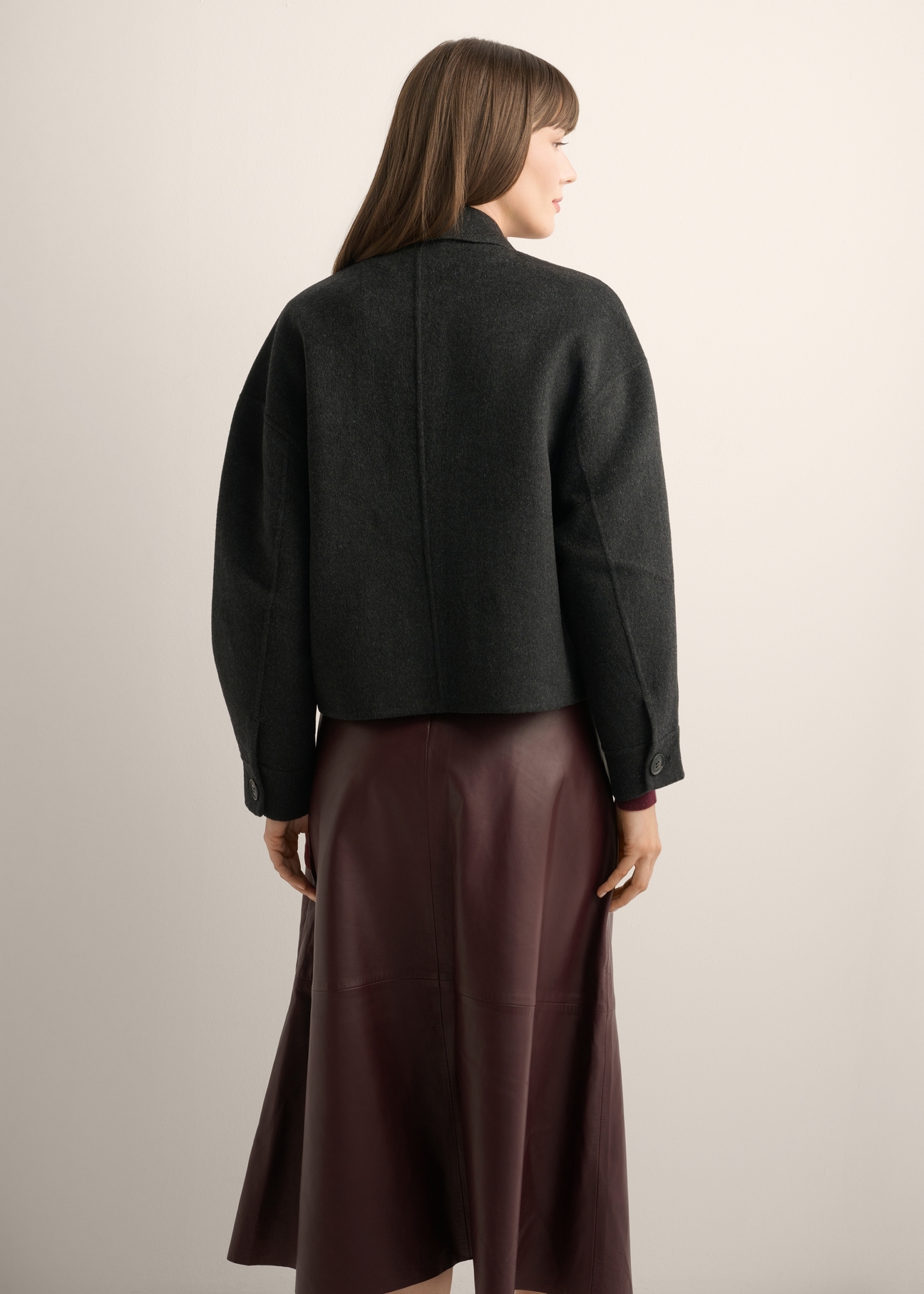 Women's short black wool coat PLADT-0067-99(Z26), back view of the product on the model. Half of the silhouette visible.