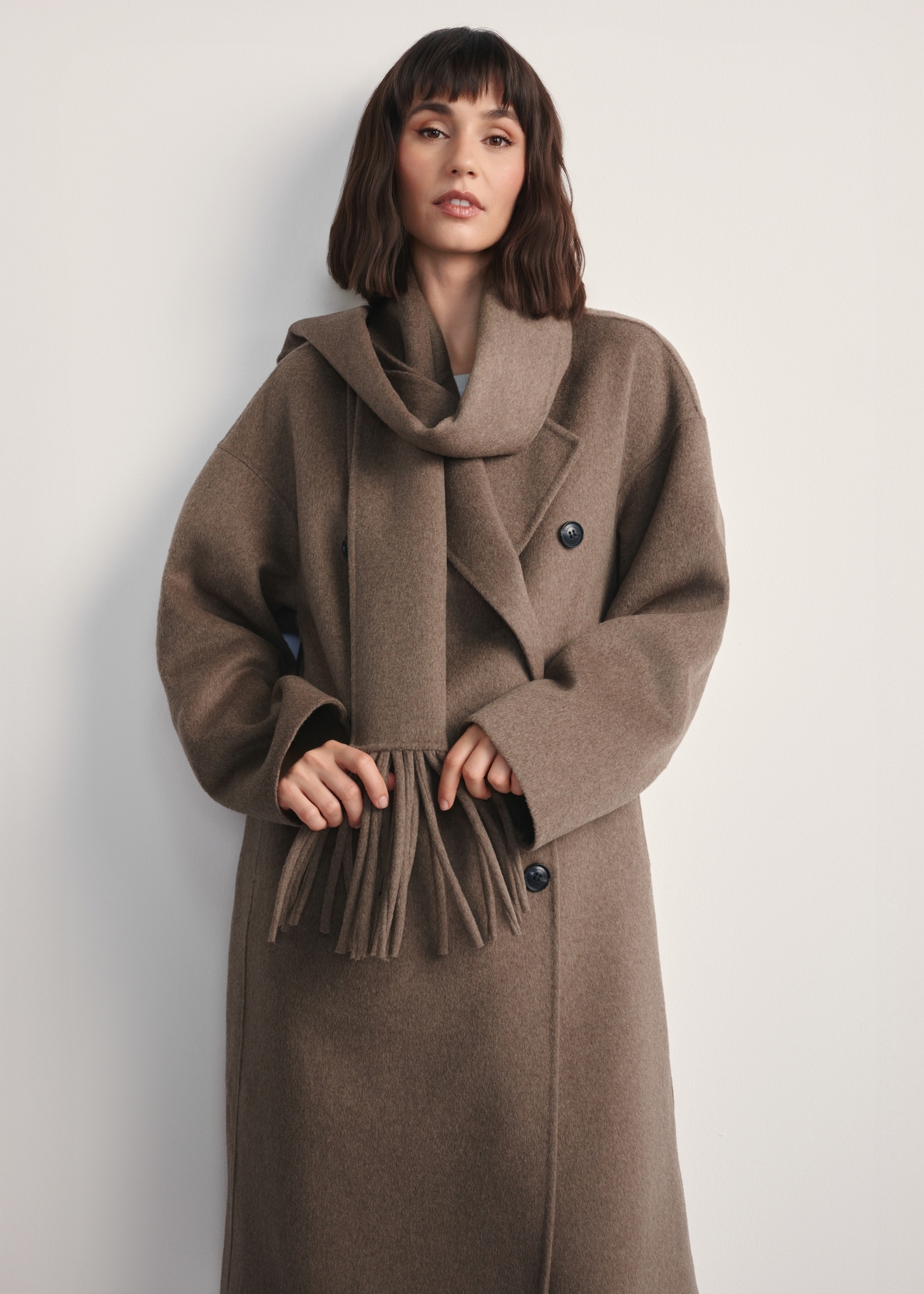 Women's dark beige coat with scarf PLADT-0063-82(Z25) - front view of the product on a model against a white background. Knee-length silhouette visible.