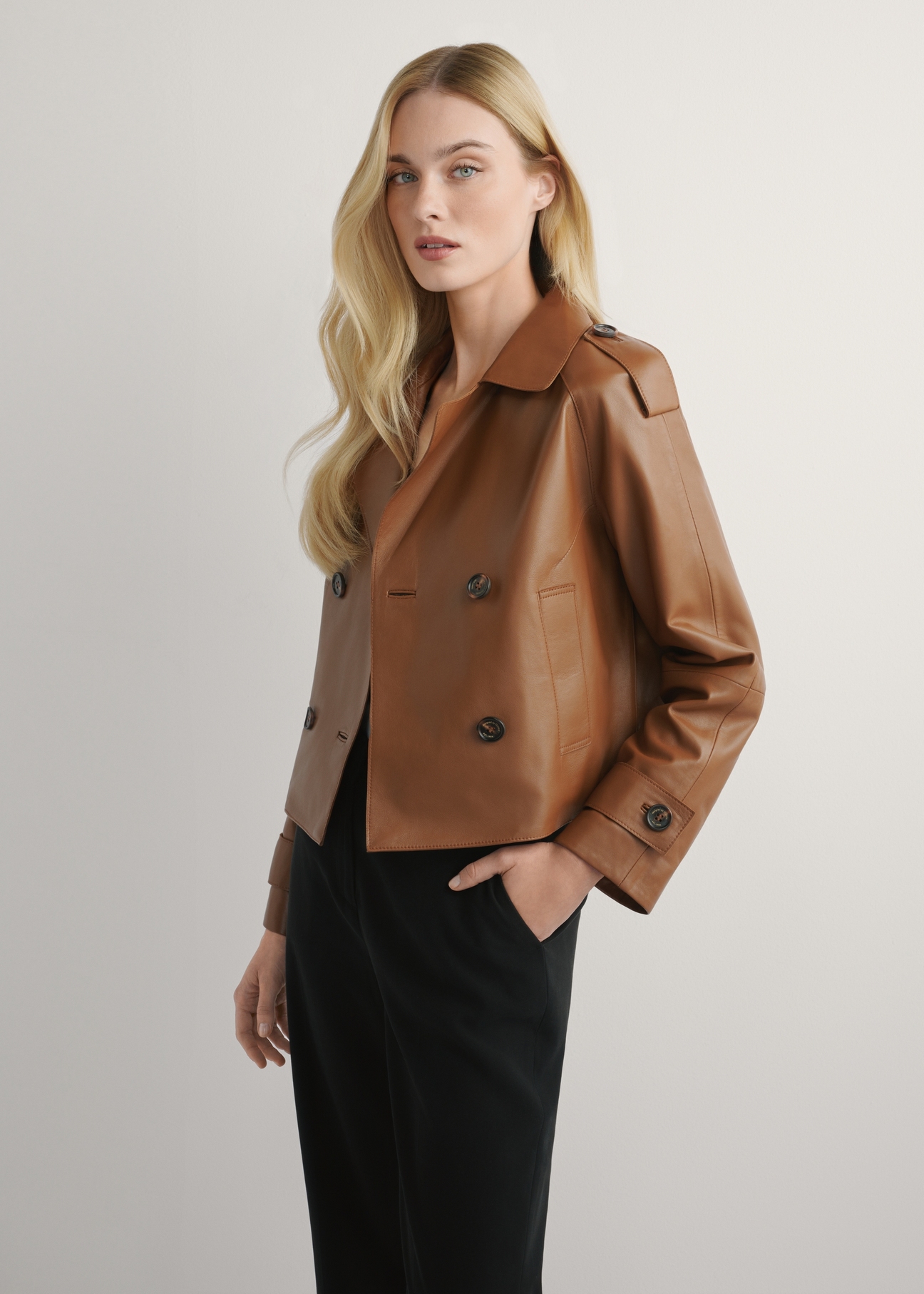 Women's oversized short leather jacket in camel color KURDS-0540-1D(W26), side view of the product on the model. Half of the silhouette visible.