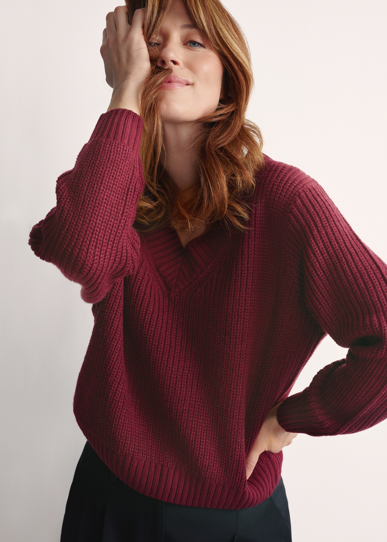 Burgundy women's V-neck sweater SWEDT-0162-49(Z25), front view of the product on the model, half of the silhouette visible.-02