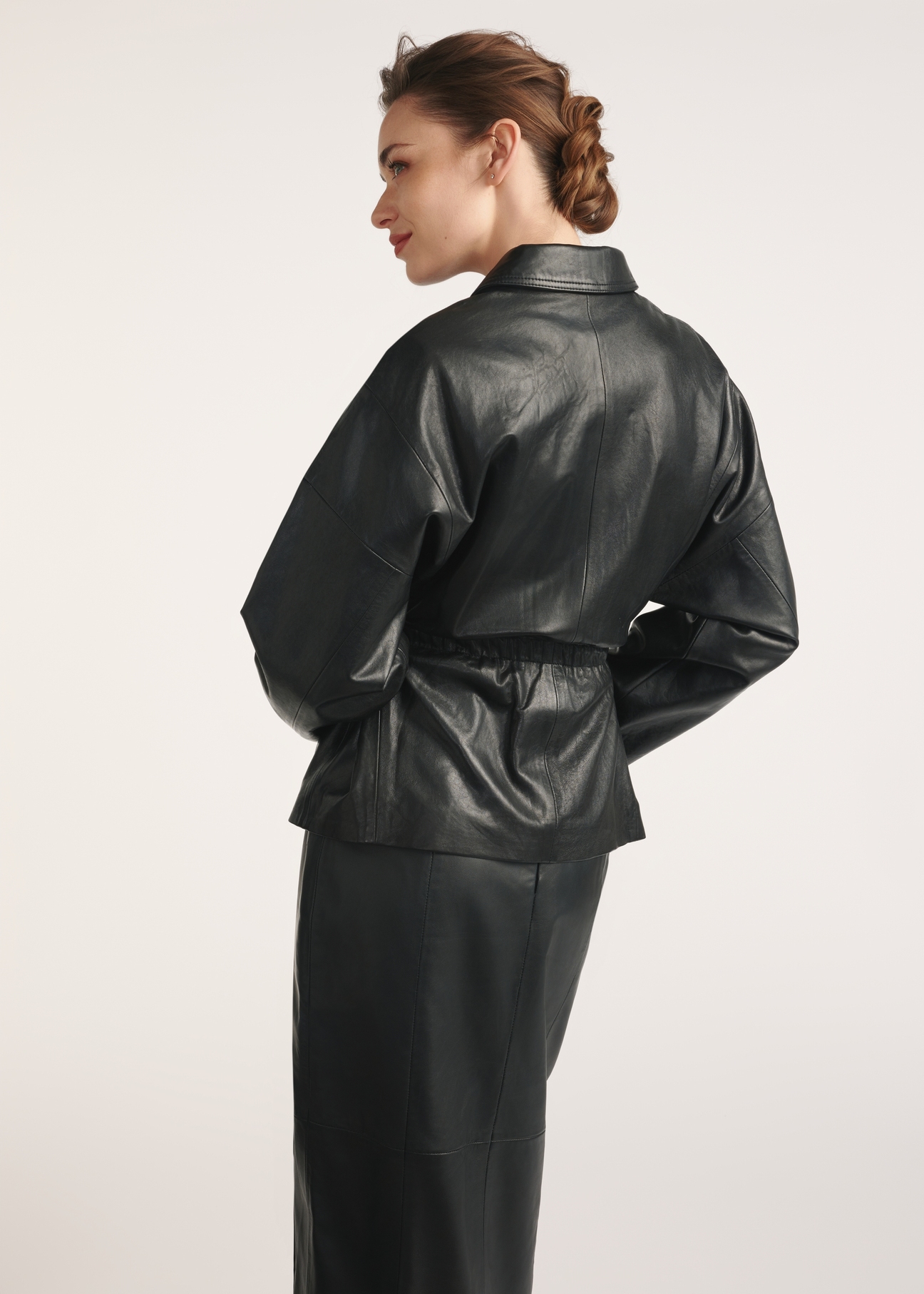 Black women's leather jacket with ties KURDS-0547-2861(Z25), product view from the back on the model, half of the silhouette visible.