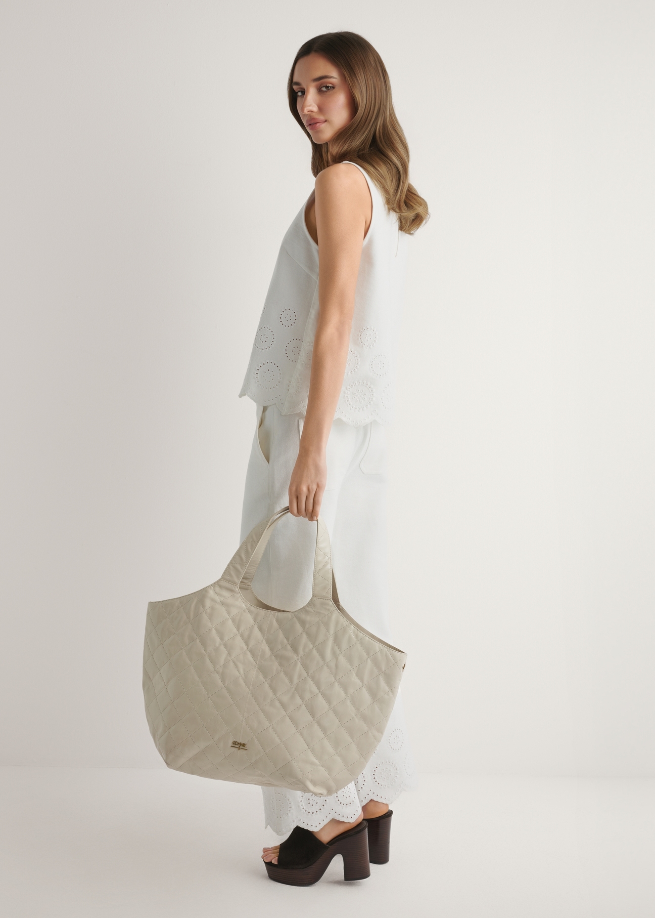 Large quilted leather women's handbag TORES-1306-0B(W26), front view of the product in the model's hand.